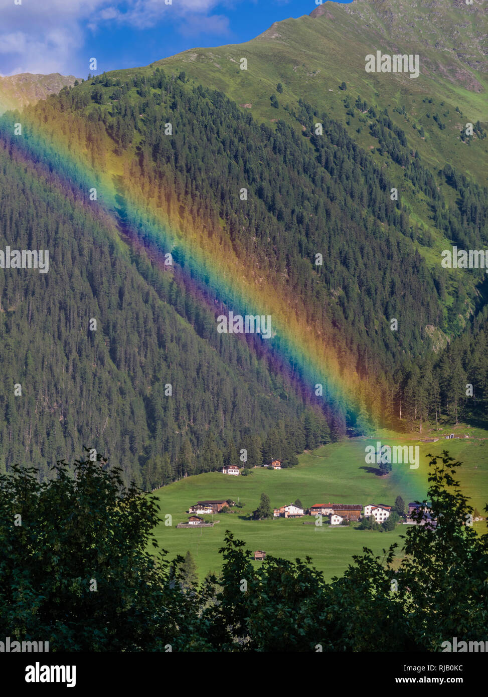 Regenbogen bei Davos Wiesen in den Bündner Bergen Stock Photo