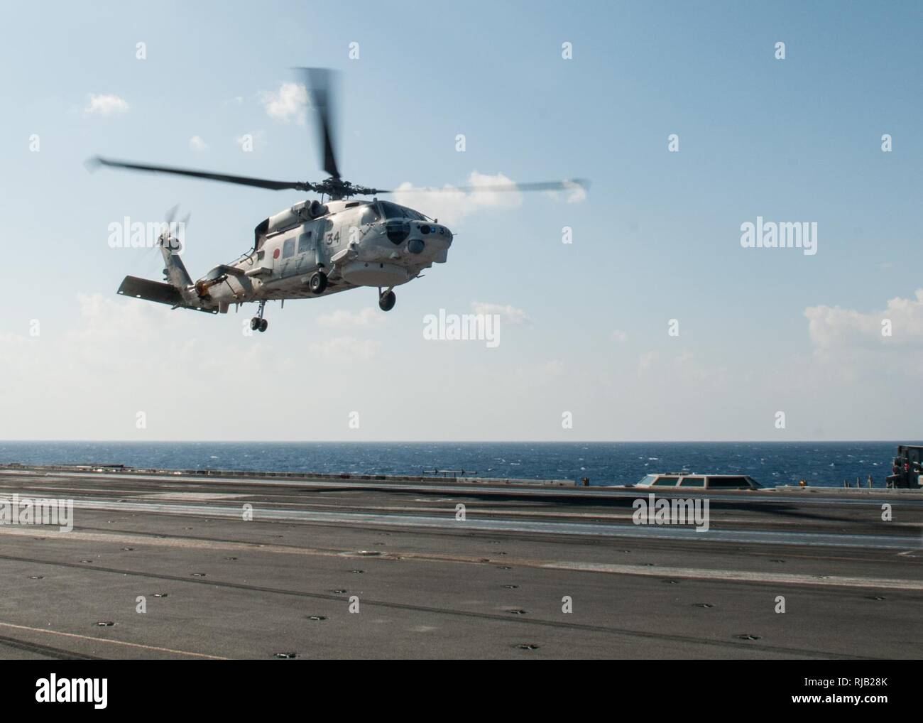 A Japanese MH-60J Super Hawk lands on the flight deck of the Navy’s only forward-deployed aircraft carrier, USS Ronald Reagan (CVN 76), during Exercise Keen Sword 17 (KS17). Ronald Reagan is participating in KS17, a biennial, Chairman of the Joint Chiefs of Staff-directed, U.S. Pacific Command-sponsored field-training exercise. KS17 is designed to meet mutual defense objectives by increasing combat readiness and interoperability between U.S. forces and the Japan Self Defense Force. Ronald Reagan, the flagship of Carrier Strike Group Five (CSG 5), is on patrol in the Philippine Sea supporting s Stock Photo