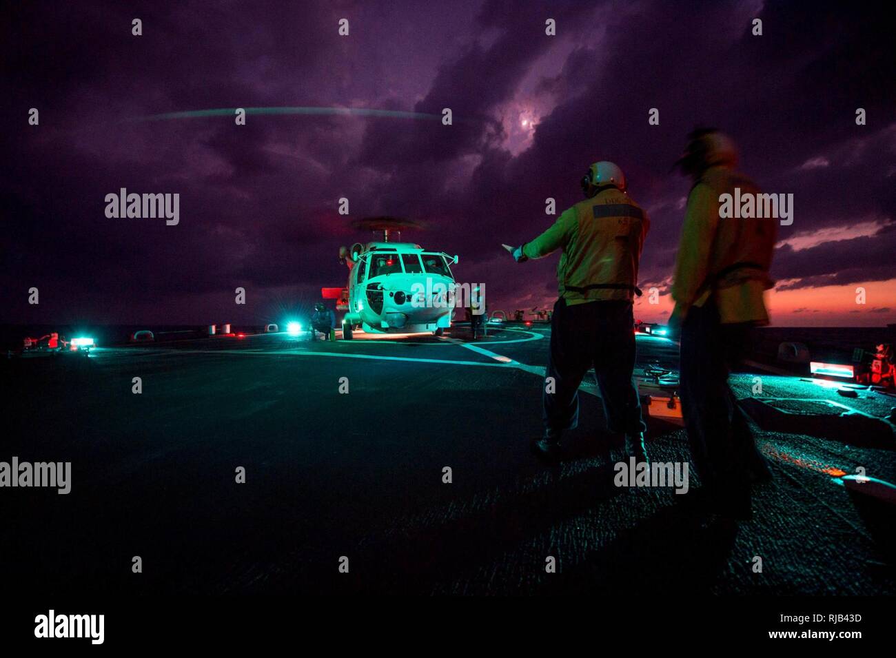 WATERS EAST OF JAPAN (Nov. 4, 2016) Petty Officer 3rd Class Xavier N. Woods directs an SH-60K Sea Hawk helicopter from the Japan Maritime Self-Defense Force (JMSDF) off the flight deck of the forward-deployed Arleigh Burke-class guided-missile destroyer USS Barry (DDG 52) during Keen Sword 17 (KS17). KS17 is a biennial, Chairman of the Joint Chiefs of Staff-directed, U.S. Pacific Command-sponsored Field Training Exercise (FTX). KS17 is a joint/bilateral FTX designed to meet mutual defense objectives by increasing combat readiness and interoperability between Japan Self-Defense Forces (JSDF) an Stock Photo