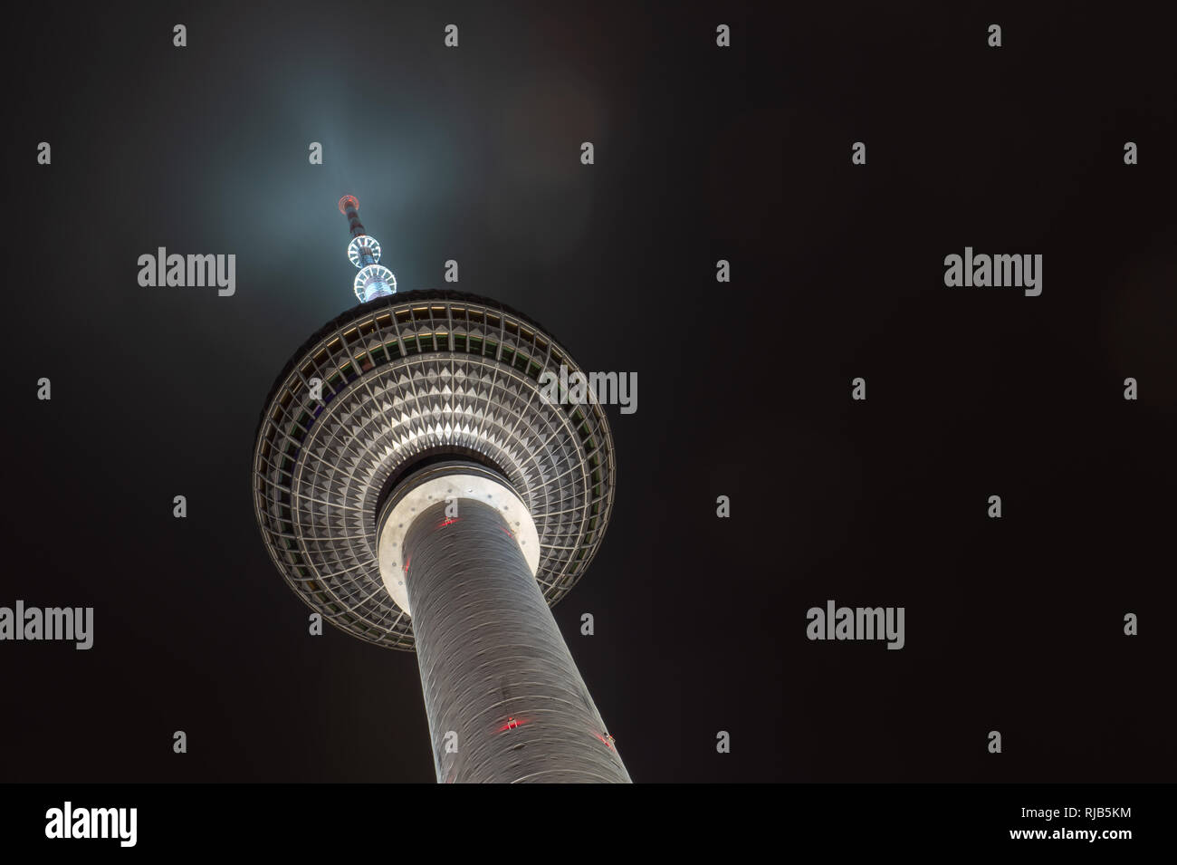 ,Background of a modern building in a popular European city. Berlin Germany. Silver sphere of Fernsehturm TV tower by night Stock Photo