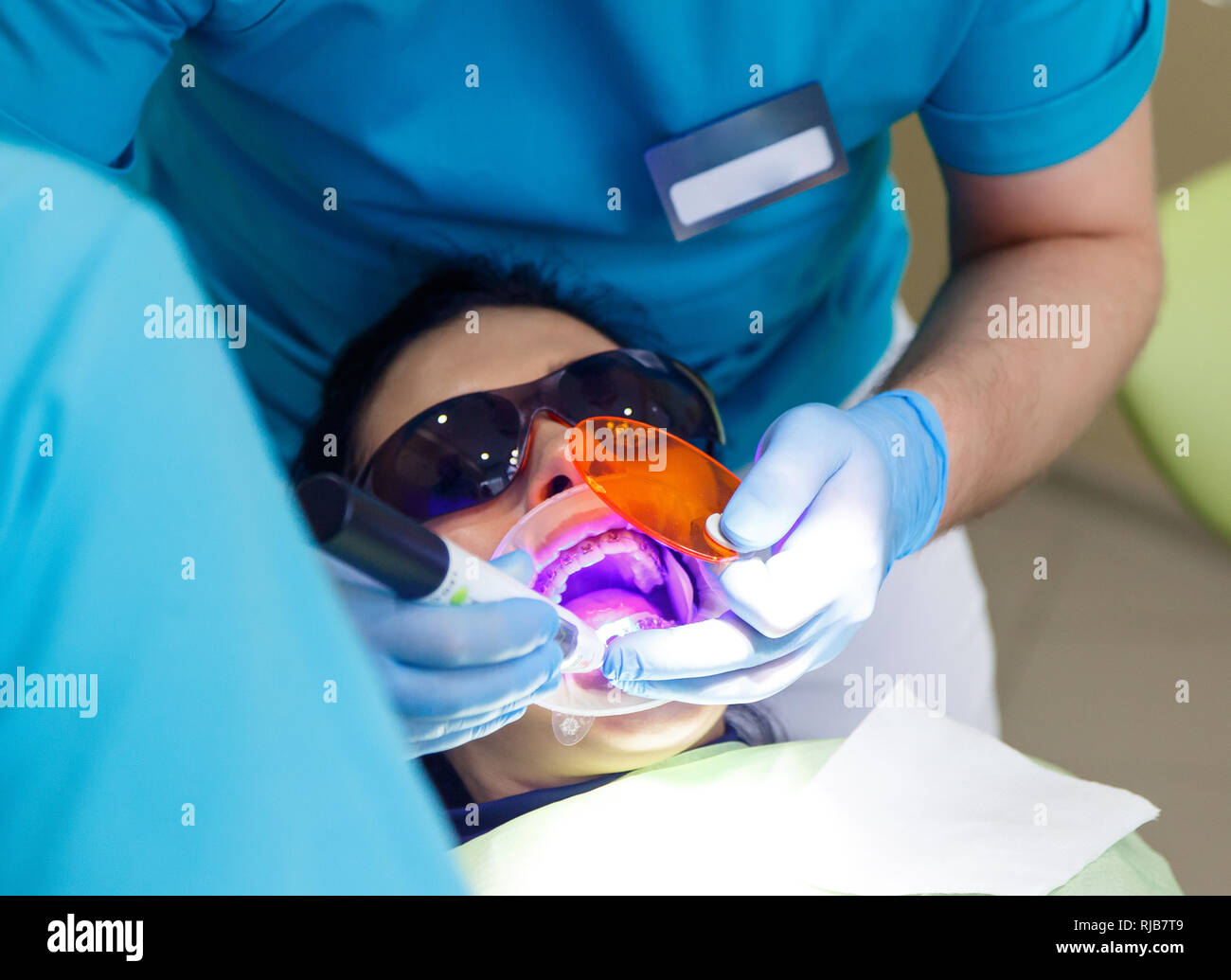 Smiling pretty woman is having her teeth examined by dentist in clinic. Concept of caries treatment Stock Photo