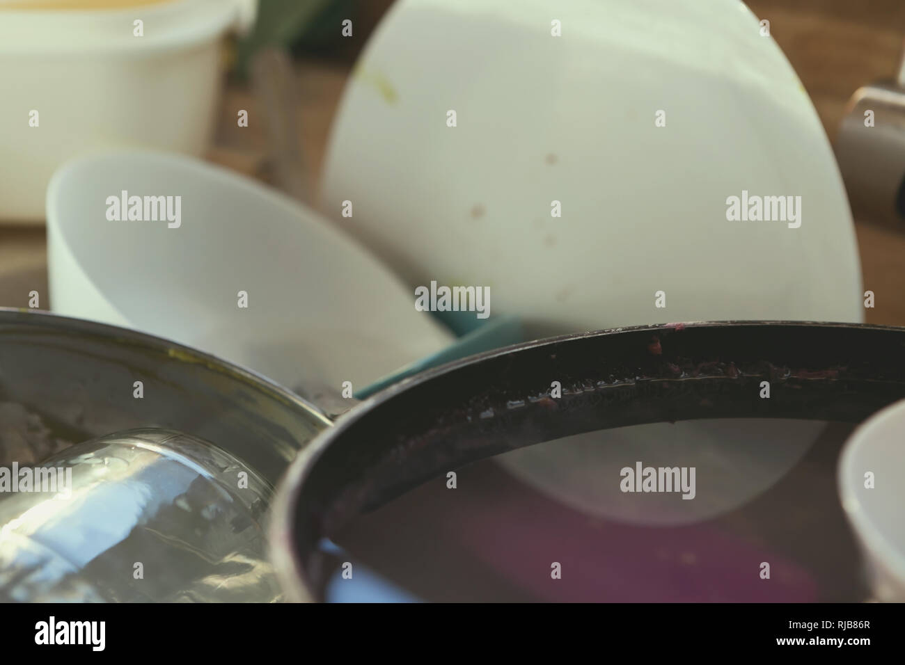 A Messy Pile of Dirty Dishes And Utensils In Kitchen Sink Stock Photo