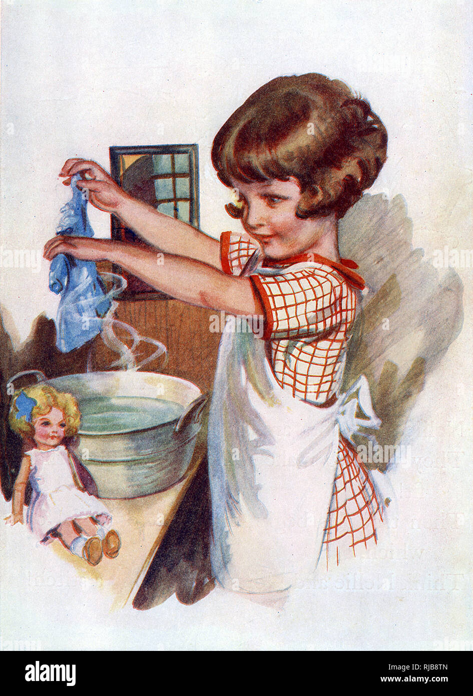 A little girl in an apron washes her doll's clothes in a tin wash basin. Stock Photo