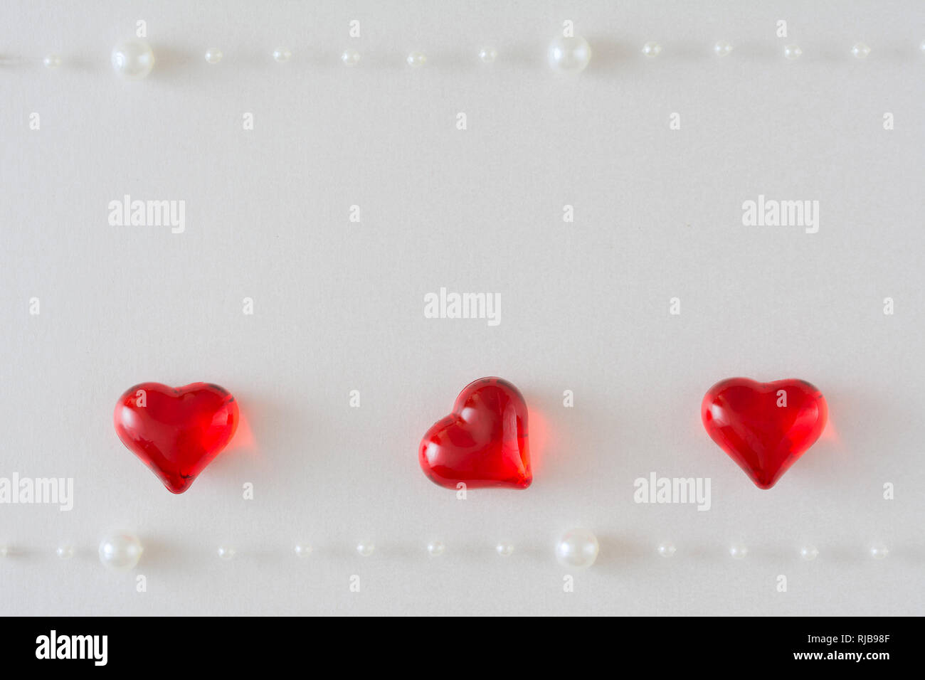 Valentine Wedding Card Background With Three Shiny Hearts On A White Background With Two Strings Of White Pearls One Heart On Its Side Stock Photo Alamy Valentine Wedding Card Background With Three Shiny Hearts On A White Background With Two Strings Of White Pearls One Heart On Its Side Stock Photo Alamy