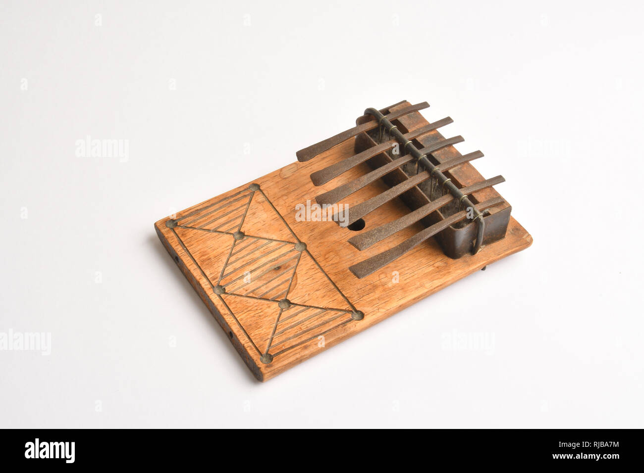 African Thumb Piano. Kalimba, mbira.The mbira is an African musical instrument consisting of a wooden board  with attached staggered metal tines. Stock Photo