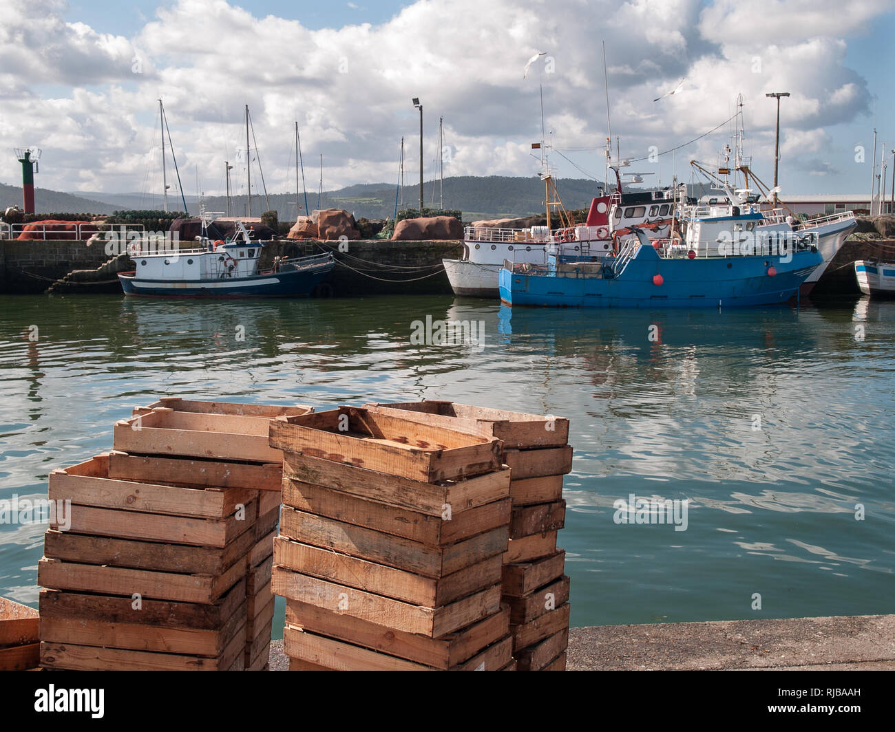 Wooden fishing crates stacked and fishing harbor. Atlantic coast harbor landscape. Fishing industry concept Stock Photo