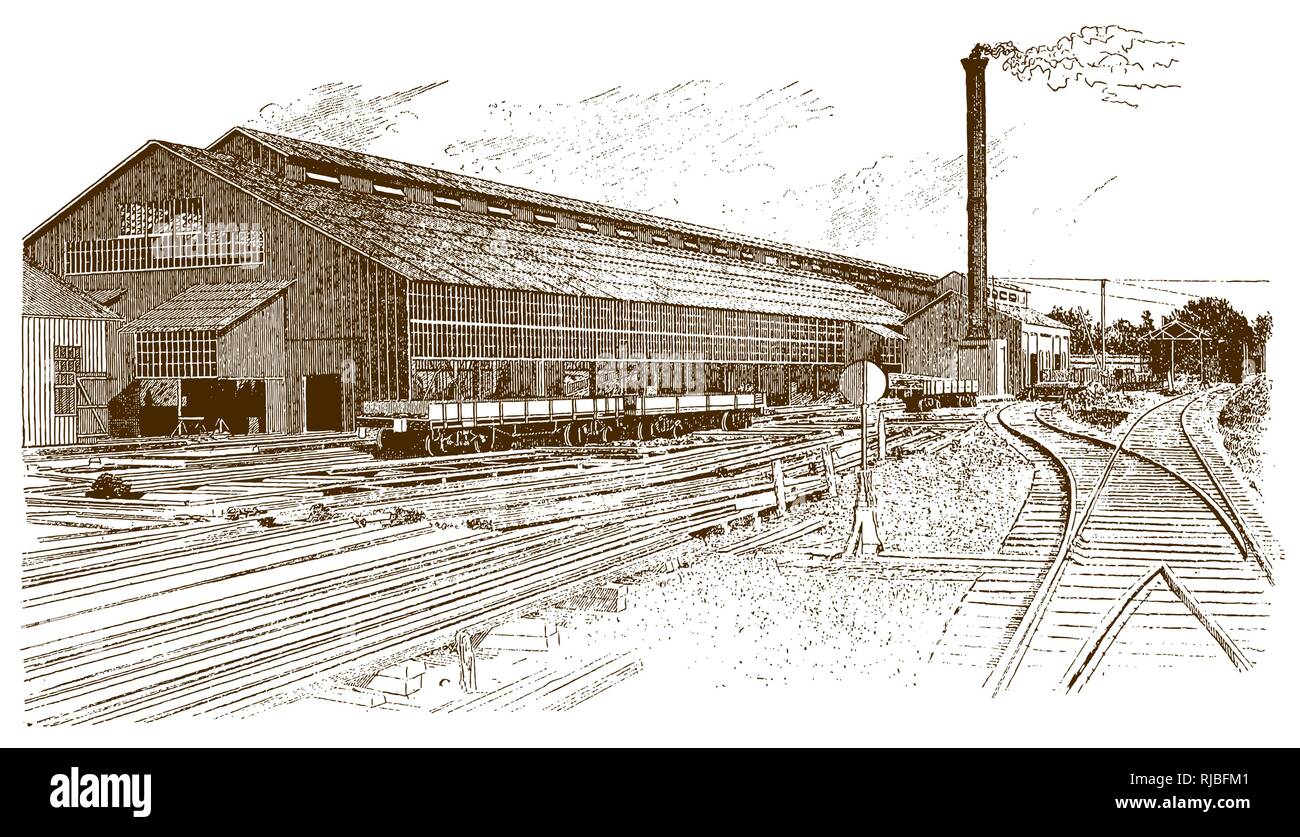 Exterior view of a historic factory building with rails, wagons and a