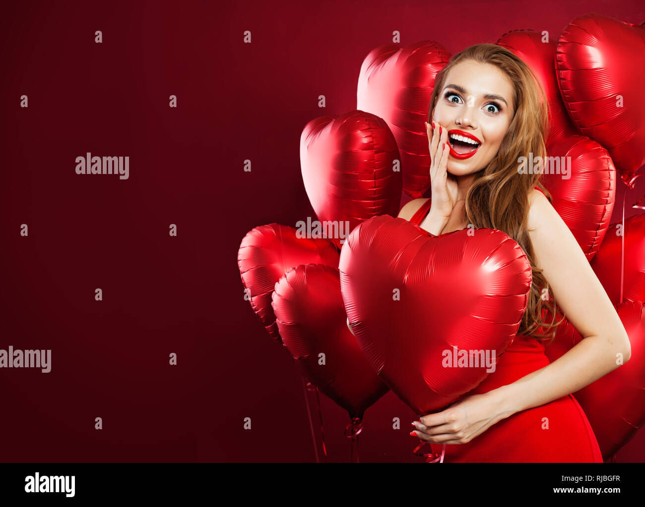 Happy woman in red dress holding balloons red heart on red banner ...