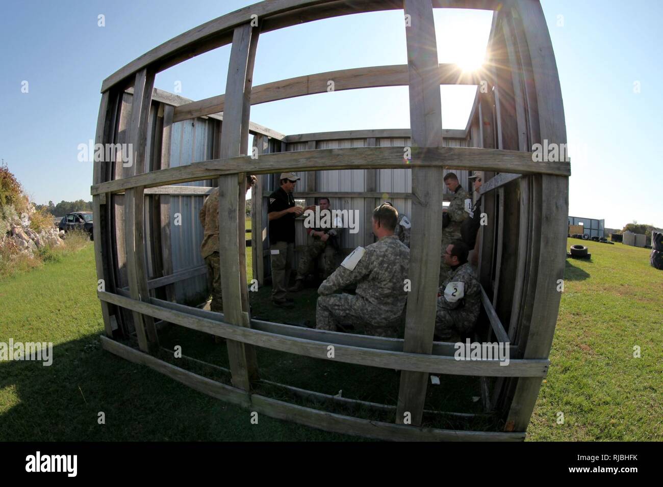 Soldiers assigned to 4th Military Information Support Group assess their performance of the near-ambush lane with Gryphon Group Security Solutions cadre, Nov. 2, 2016. The lane includes a vehicle rollover, high-speed chase, and controlled vehicle collisions. Soldiers conducting pre-mission training for an upcoming deployment to U.S. Army Central Command’s area of operations learned to maneuver vehicles through tight environments at high speeds, advanced marksmanship and gun-fighting techniques during the week-long course at the Fort Bragg Combat Training Center in Maxton, North Carolina. Stock Photo