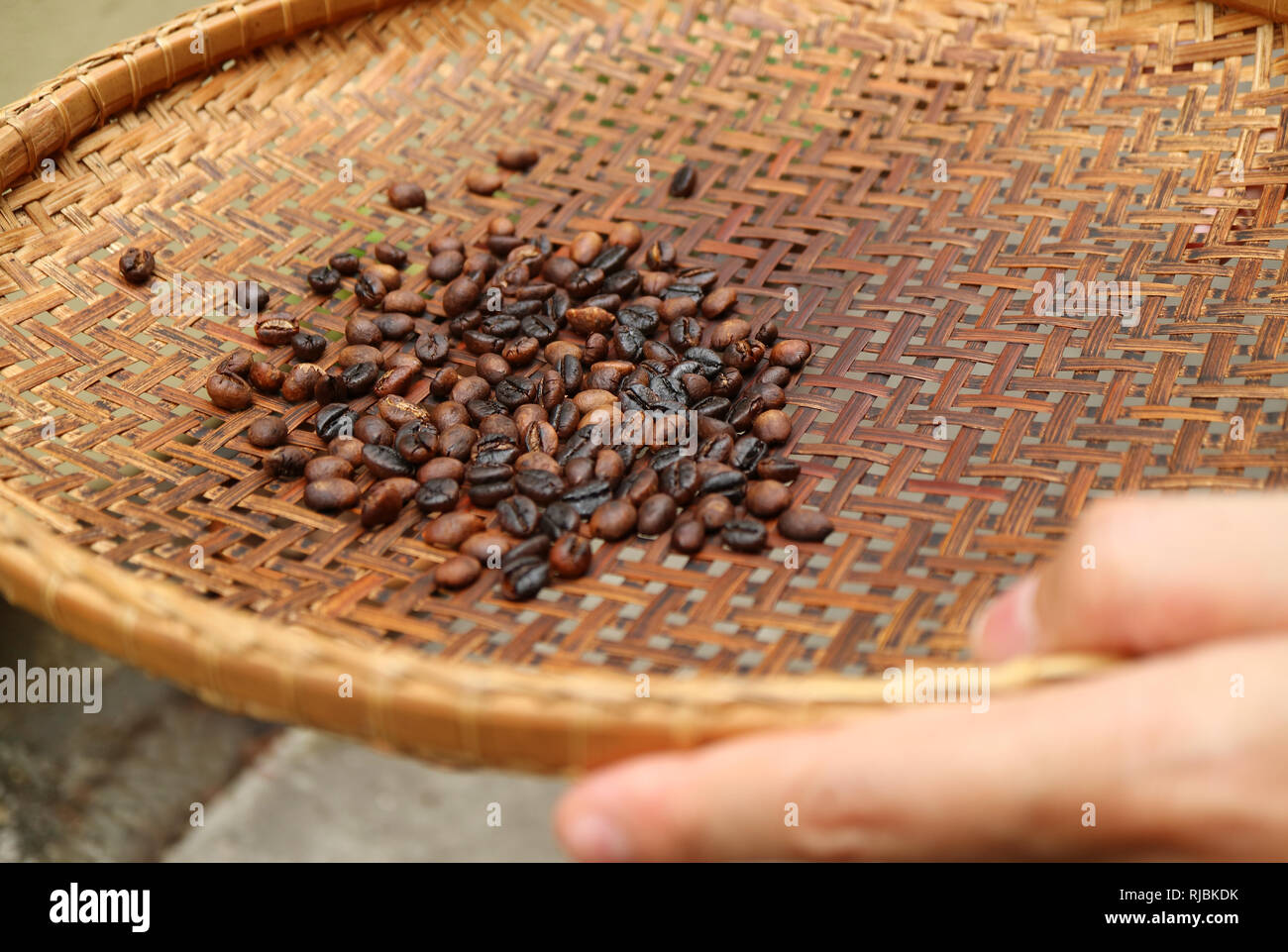 Sieving dark roasted coffee beans with threshing basket for making