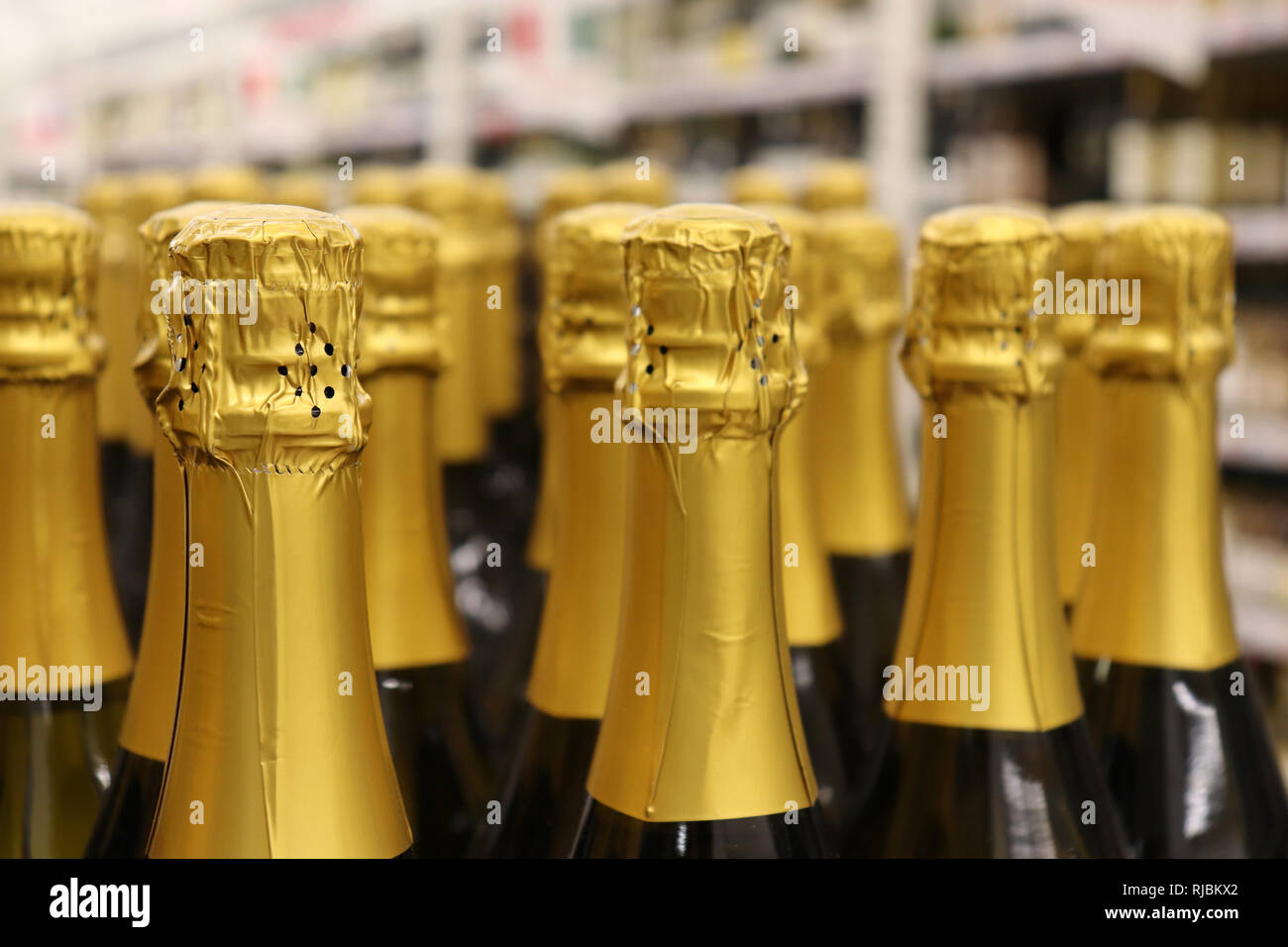 Champagne bottles in a row, selective focus. Sparkling wine production concept, liquor store Stock Photo