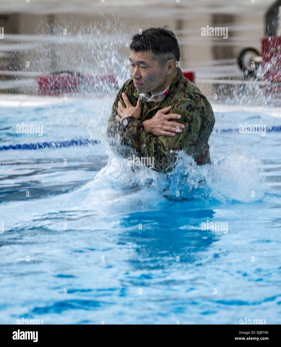 MARINE CORPS BASE CAMP PENDLETON, California – A Japan Ground Self Defense Force soldier jump from a 15 foot diving board into a pool to conduct a Marine Corps intermediate swim qualification as part of exercise Iron Fist Jan. 16, 2018. Iron Fist brings together U.S. Marines from the 11th Marine Expeditionary Unit and Soldiers from the Japan Ground Self Defense Force, Western Army Infantry Regiment, to improve bilateral planning, communicating, and conduct combined amphibious operations. Stock Photo