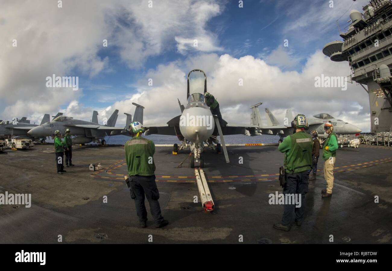 PACIFIC OCEAN (Jan. 11, 2018) Sailors perform maintenance on an F/A-18E Hornet assigned to the “Kestrels” of Strike Fighter Squadron (VFA) 137 on the flight deck of the Nimitz-class aircraft carrier USS Carl Vinson (CVN 70) flight deck. The Carl Vinson Strike Group is currently operating in the Pacific as part of a regularly scheduled deployment. Stock Photo