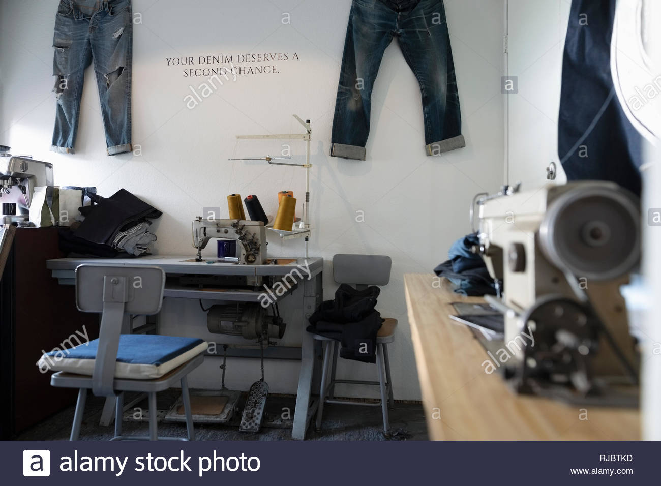 Sewing machines and jeans in denim repair shop Stock Photo Alamy