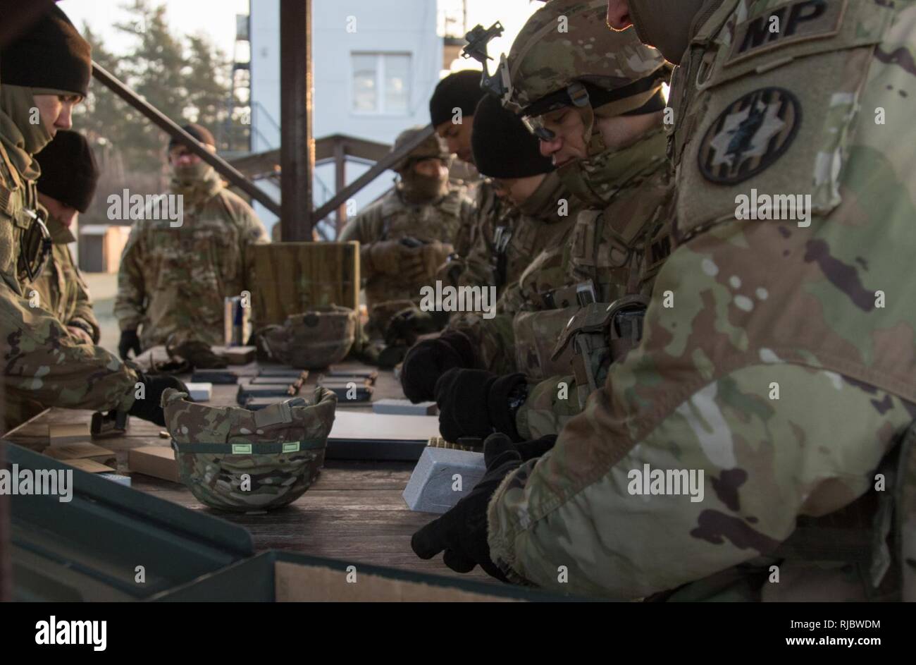 U.S. Soldiers assigned to the Forward Support Troop, 3rd Squadron, 2nd Cavalry Regiment and Soldier from the 709th MP Battalion, 18th MP Brigade load magazines with 9mm rounds to qualify with their M9 pistols at a range near the Bemowo Piskie Training Area, Poland, Jan. 16, 2018. These Soldier are a part of the unique, multinational battle group, comprised of U.S., U.K., Croatian and Romanian soldiers serve with the Polish 15th Mechanized Brigade as a deterrence force in northeast Poland in support of NATO’s Enhanced Forward Presence. Stock Photo