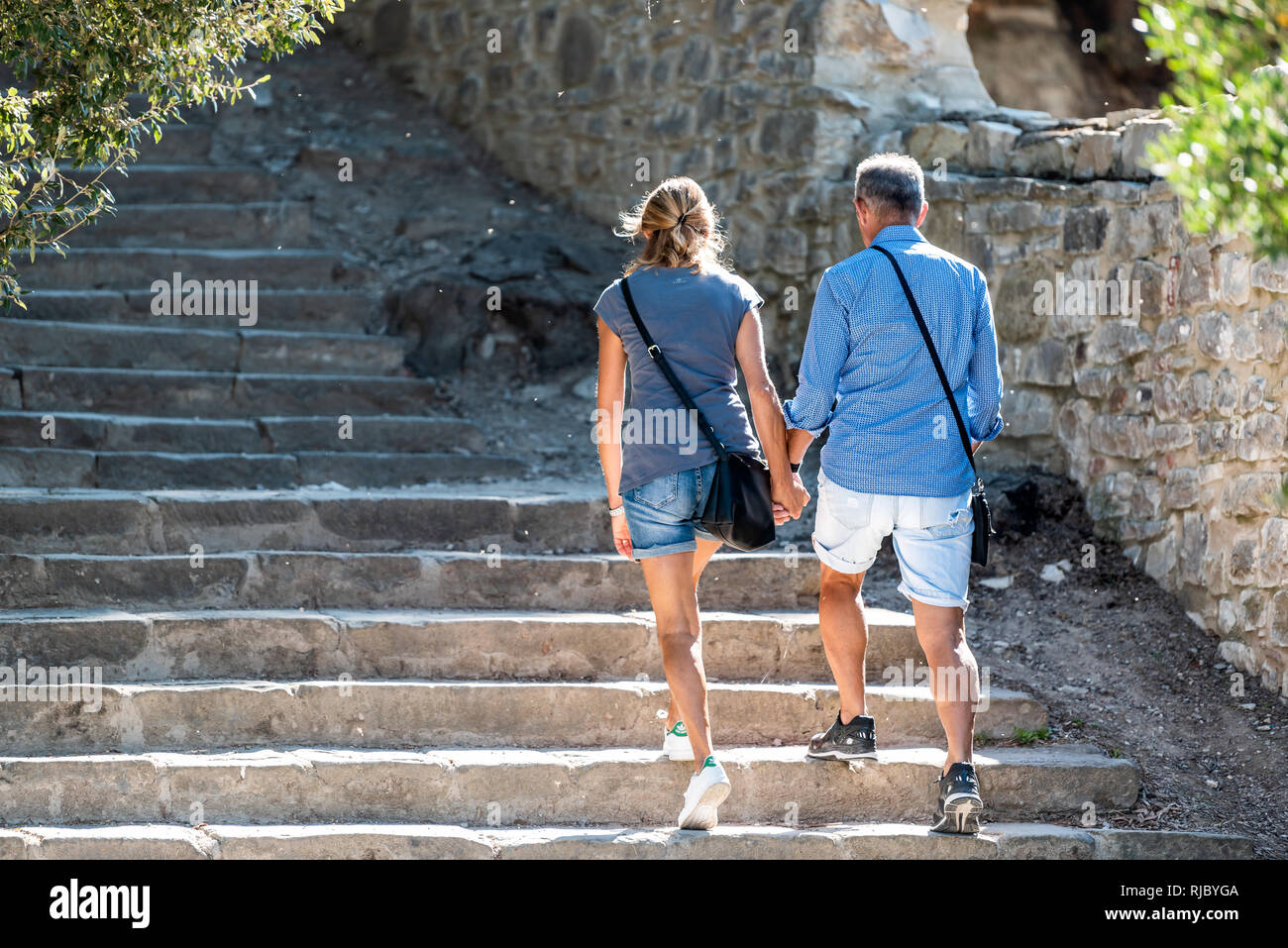 Castiglione del Lago, Italy - August 28, 2018: Fortress steps stairs in Umbria Rocca with Medievale o Rocca del Leone and people tourist couple holdin Stock Photo