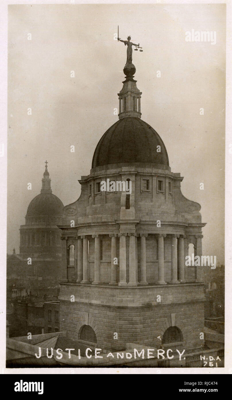 The dome and statue atop London's Central Criminal Court and the dome of St. Paul's Cathedral - the card is beautifully captioned as 'Justice and Mercy'. Stock Photo