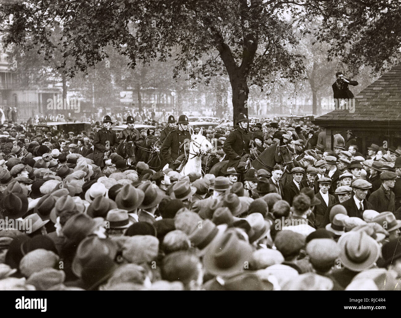 The National Hunger March of September – October 1932 was the largest of a series of hunger marches in Britain in the 1920s and 1930s. Unemployed Men and Women who have walked from all parts of the country, hold a Mass Demonstration in Hyde Park, London - a mounted police escort with some of the demonstrators - 27th October 1932. Stock Photo