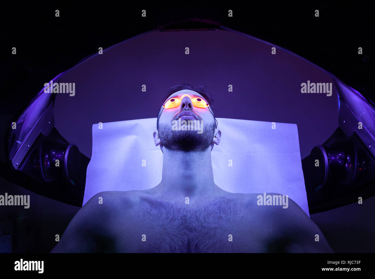Young Thin Man At Solarium In Beauty Salon. Stock Photo