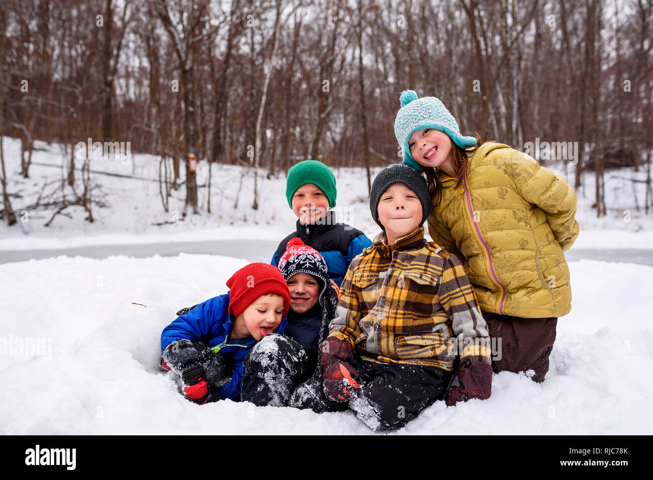 Five children sitting in the snow, Wisconsin, United States Stock Photo