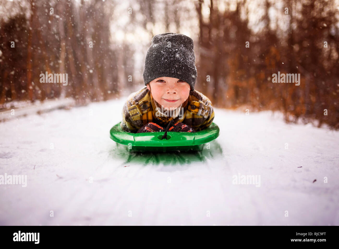 Boy lying on a sledge, Wisconsin, United States Stock Photo
