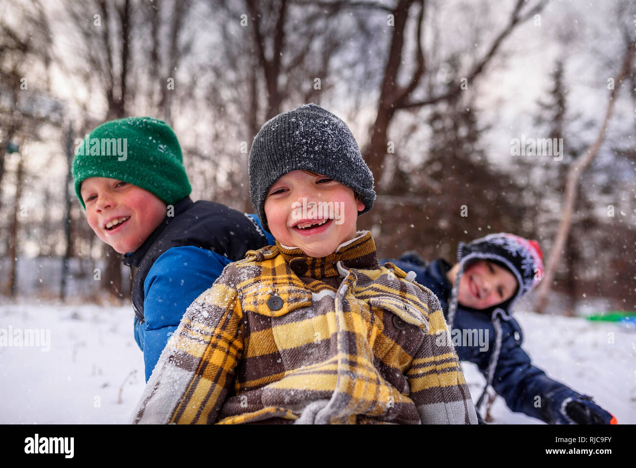 Three children messing about in the snow, Wisconsin, United States Stock Photo