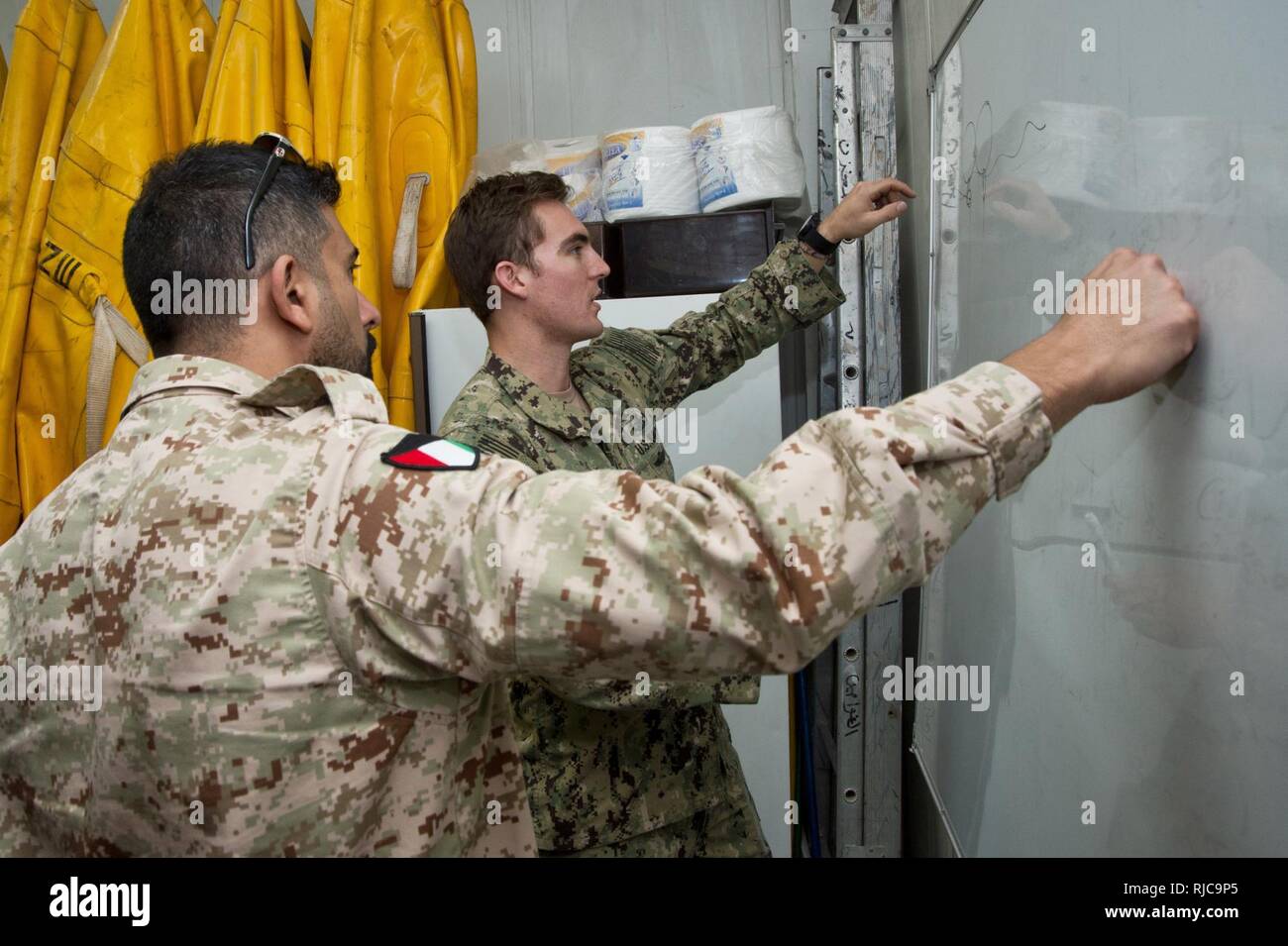 Mohammed Al-Ahmad Naval Base, (Jan. 7, 2018) Explosive Ordnance Disposal Technician 1st Class Kyle Hall, assigned to Commander, Task Group 56.1, exchanges sea mine procedures with a Kuwait Naval Force explosive ordnance disposal technician during a training evolution as part of exercise Eager Response 18. Eager Response 18 is a bilateral explosive ordnance disposal military exercise between the State of Kuwait and the United States. The exercise fortifies military-to-military relationships between the Kuwait Naval Force and U.S. Navy, advances the operational capabilities of Kuwaiti and U.S. f Stock Photo
