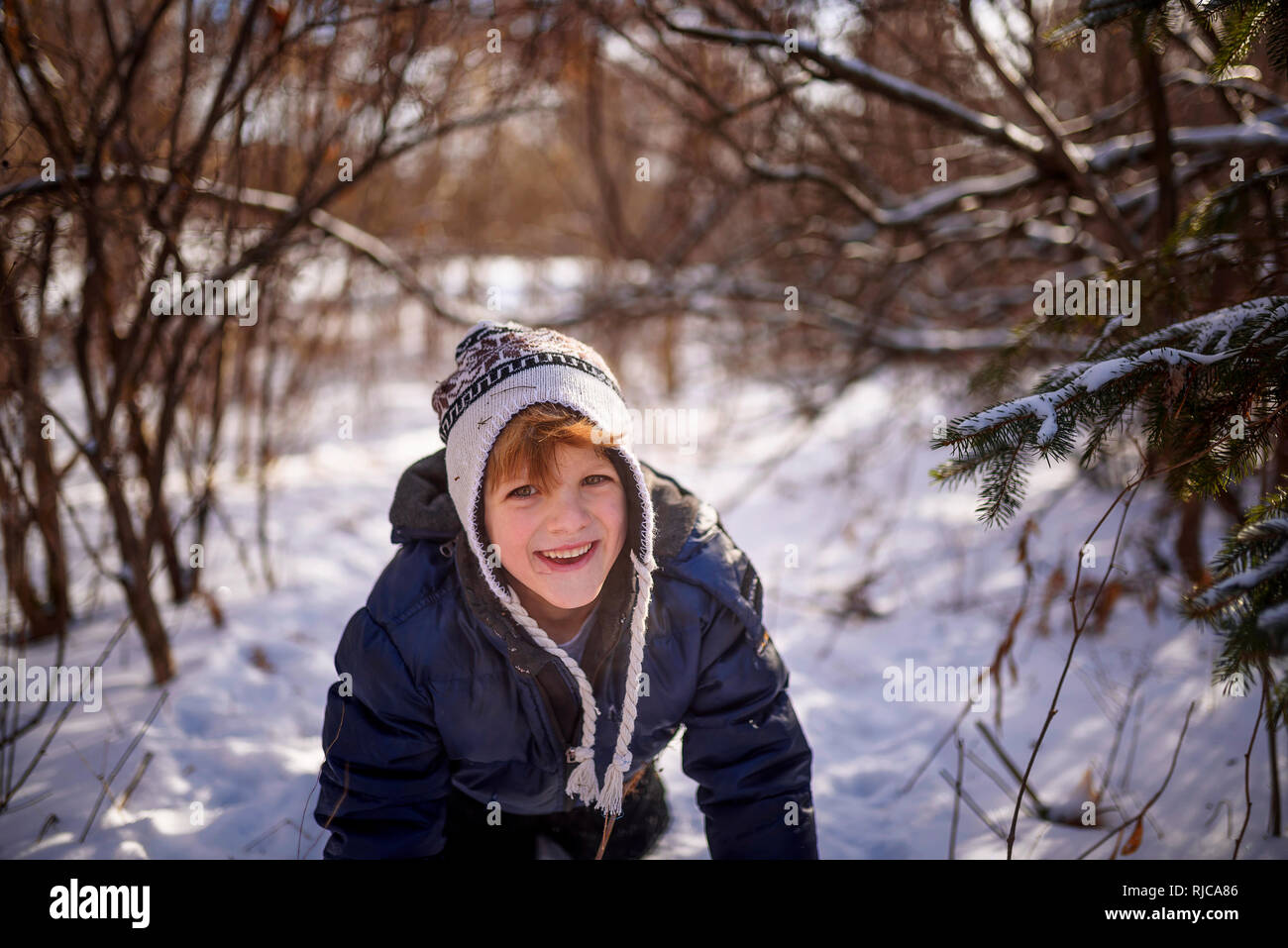 Boy crawling through the snow, Wisconsin, United States Stock Photo