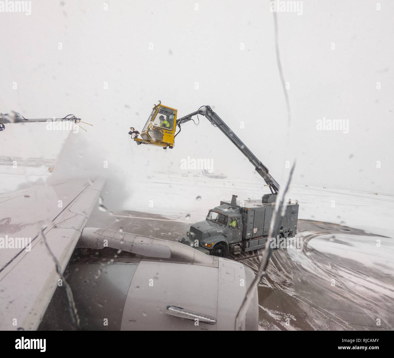 View from passenger window of de-icing of aircraft wing Stock Photo