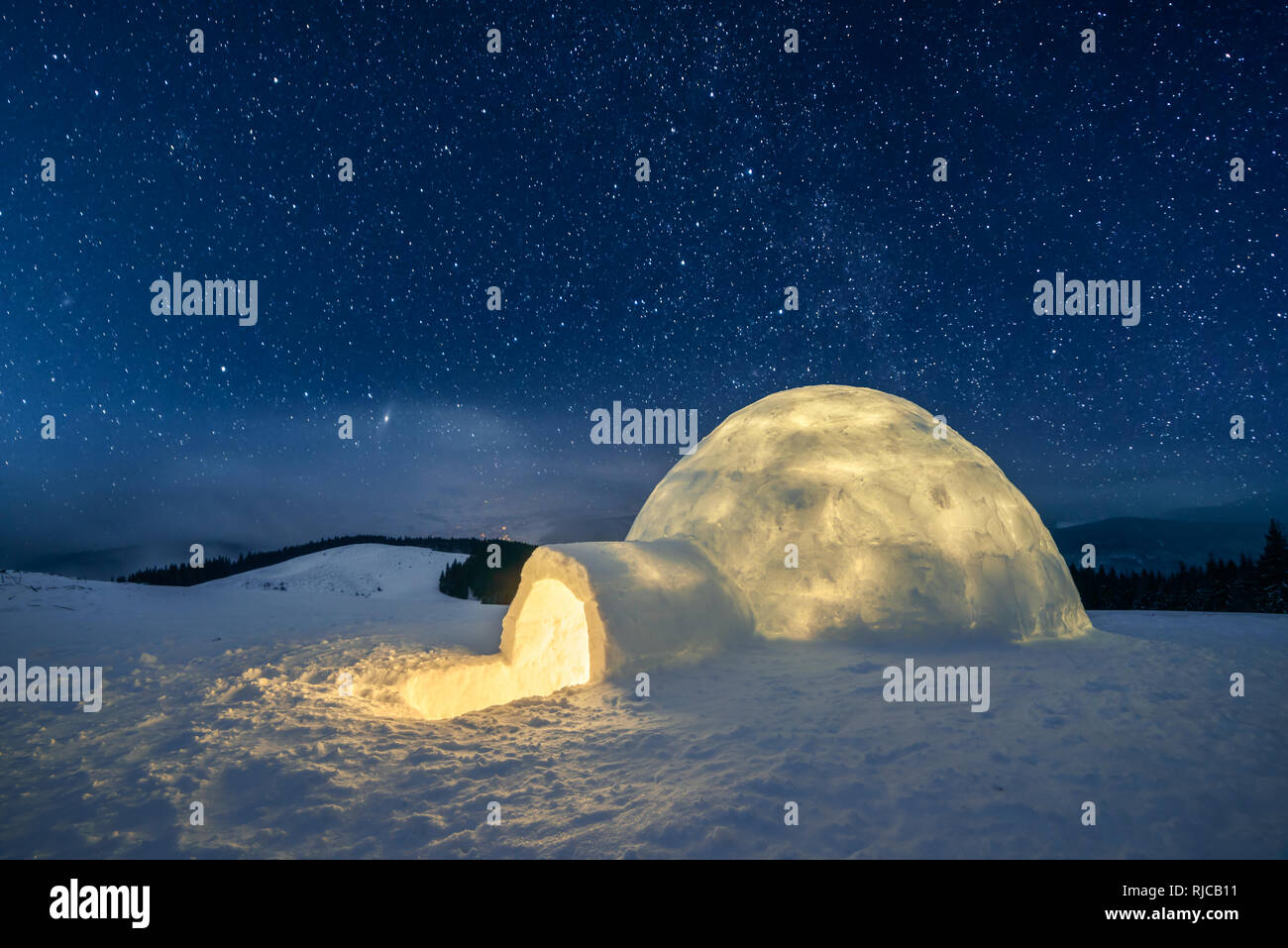 Fantastic winter landscape glowing by star light. Wintry scene with snowy igloo and milky way in night sky Stock Photo
