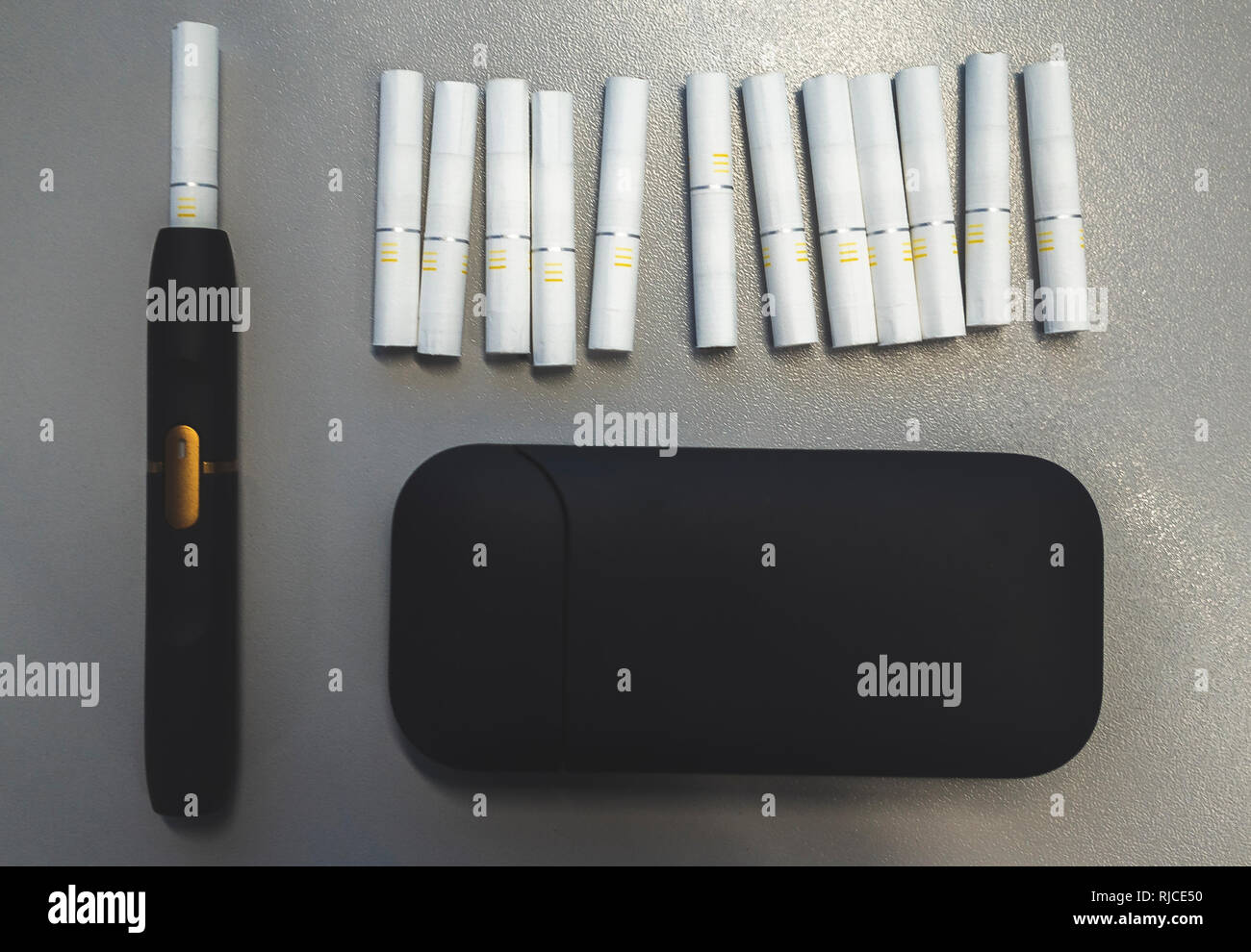 Tobacco heating system and a pack of tobacco sticks on a gray background  Stock Photo