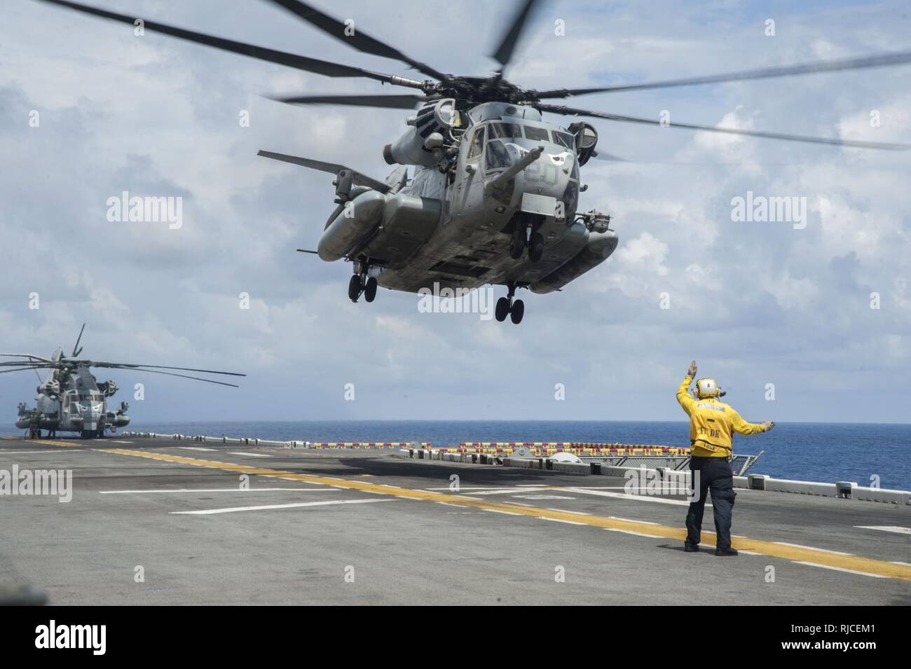 SOUTH CHINA SEA (Nov. 16, 2016) Seaman Caleb Lambert, from Modesto, Calif., directs a CH-53E Super Stallion as it launches from the amphibious assault ship USS Makin Island (LHD 8). Makin Island, the flagship of the Makin Island Amphibious Ready Group, is operating in the U.S. 7th Fleet area of operations with the embarked 11th Marine Expeditionary Unit in support of security and stability in the Indo-Asia-Pacific region. Stock Photo
