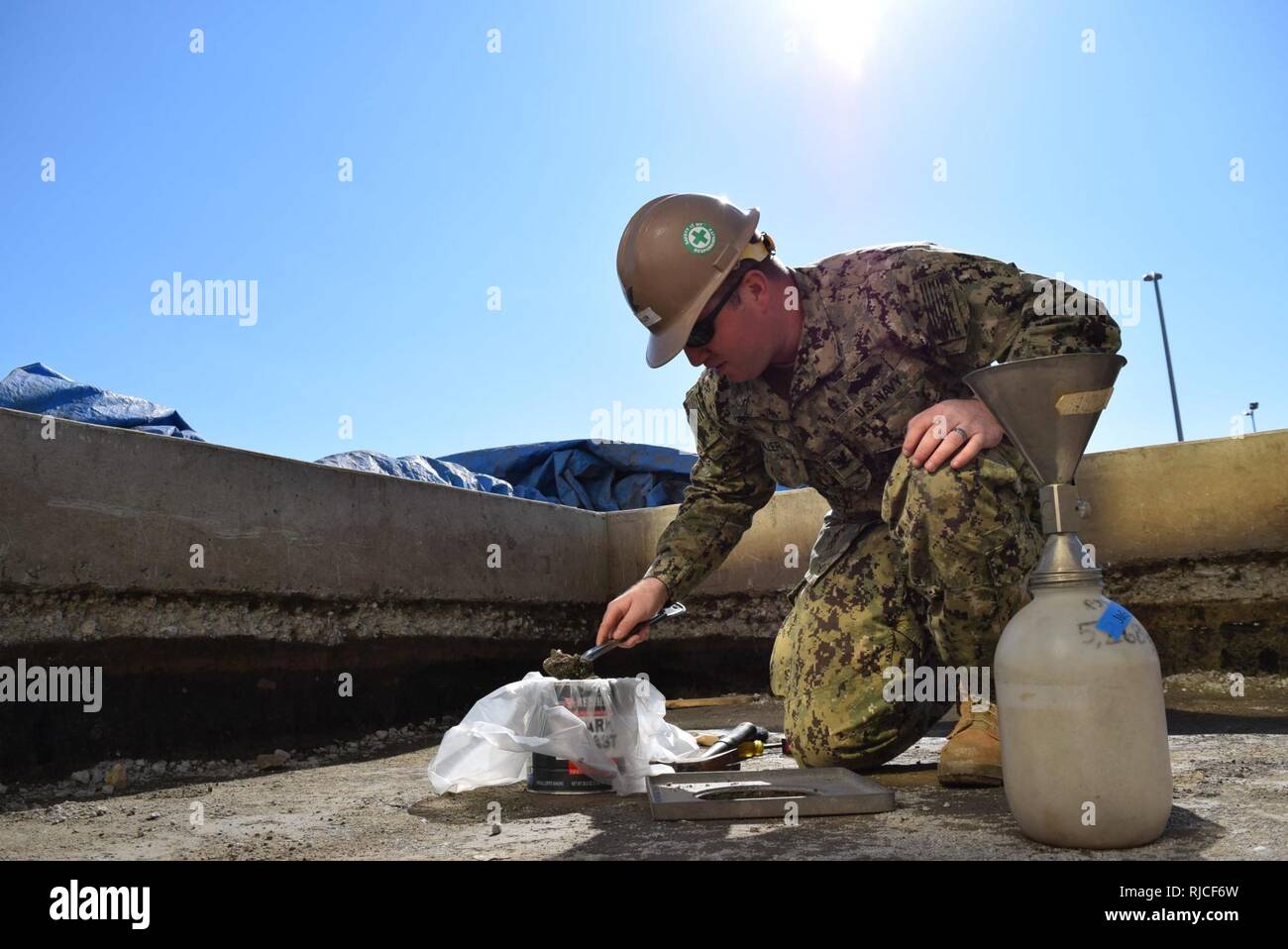 YOKOSUKA, JAPAN (Nov. 4, 2016) Petty Officer 3rd Class Aaron Miller, assigned to Naval Mobile Construction Battalion (NMCB) 5, checks soil for compaction prior to constructing a shade structure. The project will provide a 6,000 square foot shaded pavilion for Morale, Welfare, and Recreation on board Commander, Fleet Activities Yokosuka. The pavilion will be used for outdoor workouts and special events improving the base amenities and lifestyle for the Sailors there. NMCB 5 is the forward deployed Western Pacific NMCB ready to support major combat operation and Humanitarian Assistance, disaster Stock Photo