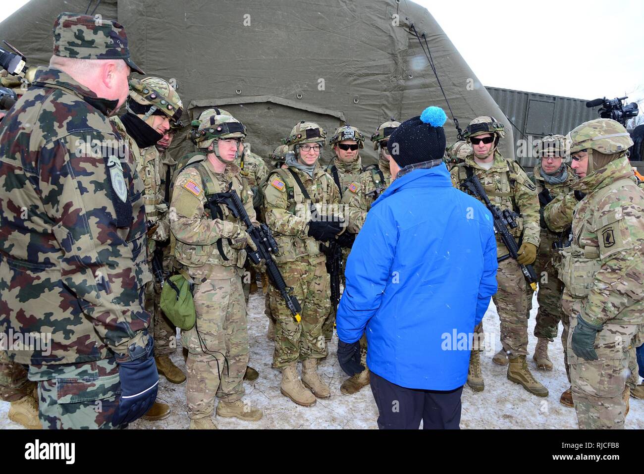 In the middle, Robert Hartley, U.S. Ambassador to Slovenia, talks with U.S. Army paratroopers from the 173rd Brigade Support Battalion, 173rd Airborne Brigade, as part of a visit during exercise Lipizzaner III at Pocek Range in Slovenia Jan. 26, 2017. Lipizzaner is a combined squad-level training exercise in preparation for platoon evaluation, and to validate battalion-level deployment procedures. ( Stock Photo