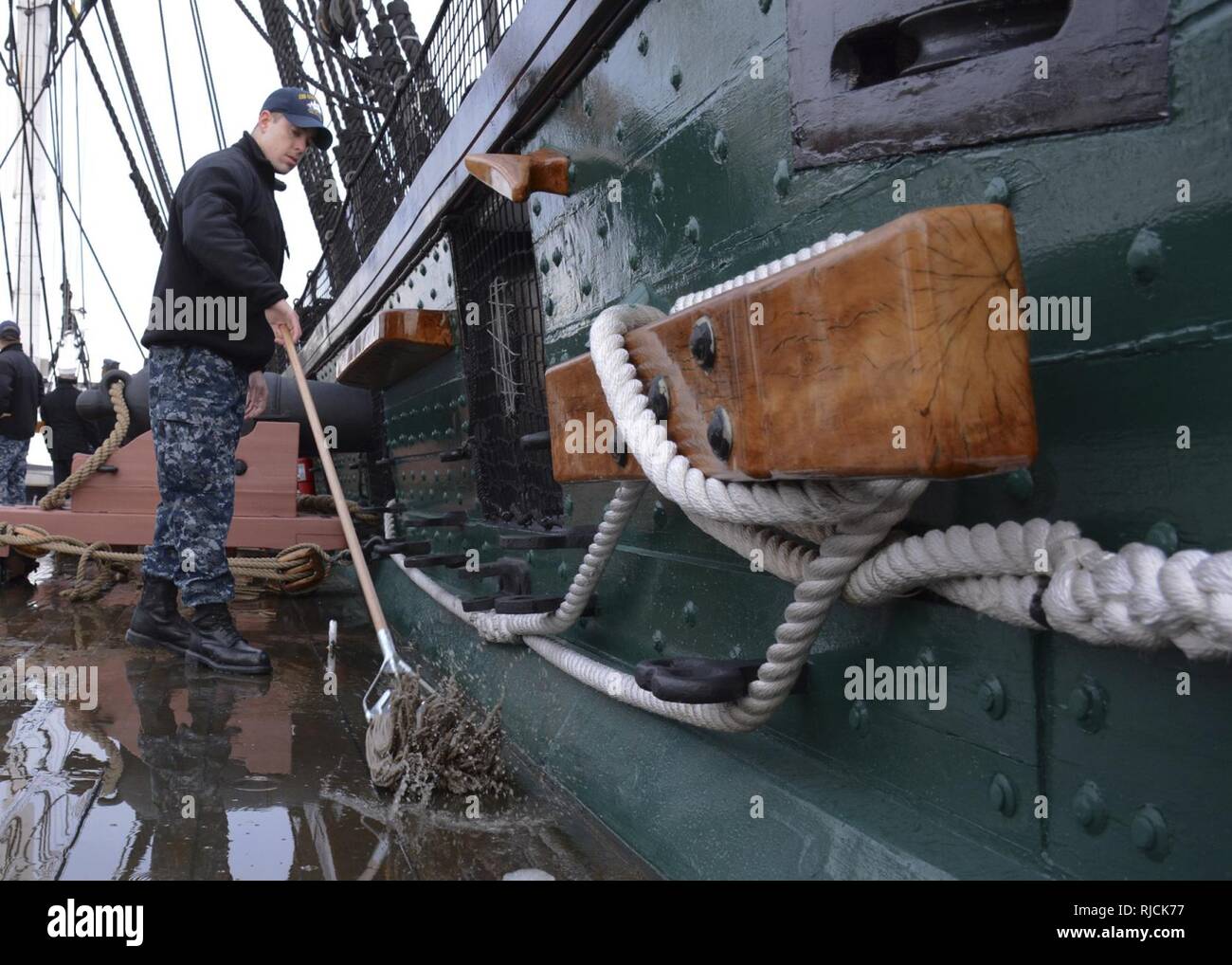 BOSTON (Jan. 11, 2018) Gas Turbine Systems Technician Mechanical 3rd Class Kyle Brennan assists in cleanup of the USS Constitution following heavy snow storms in the area. The crew maintains cleanliness daily of all spaces aboard the ship. Stock Photo
