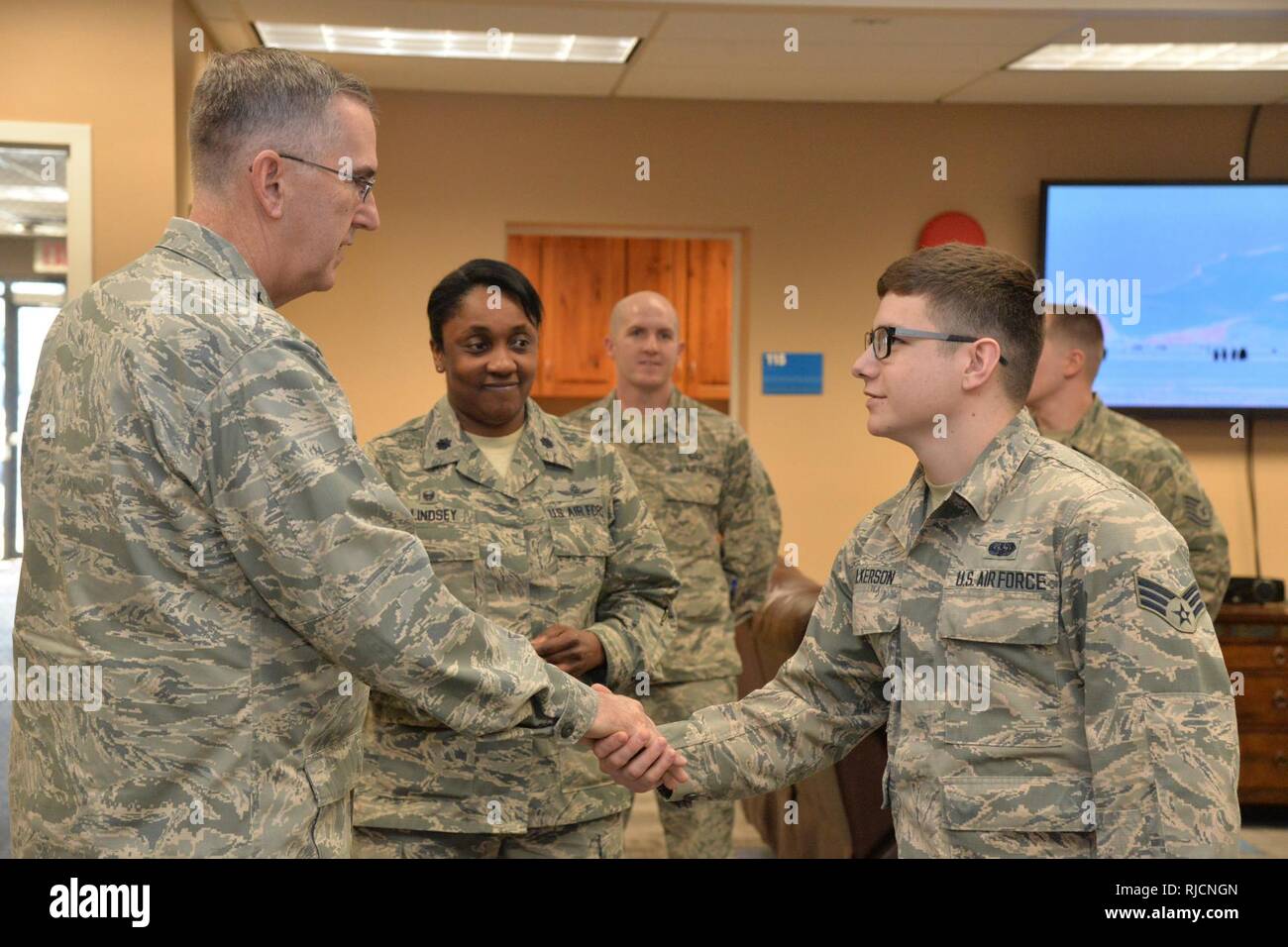 U.S. Air Force Gen. John Hyten, commander of U.S. Strategic Command (USSTRATCOM); shakes hands with Senior Airman Landon Wilkerson, 341st Communications Squadron, at the Malmstrom Air Force Base resiliency center in Montana, Jan. 16, 2018. During his visit, Hyten met with base leaders and airmen to thank them for their support to USSTRATCOM’s deterrence mission. He also toured facilities at the base, including the weapons storage area and a missile alert facility. Stock Photo