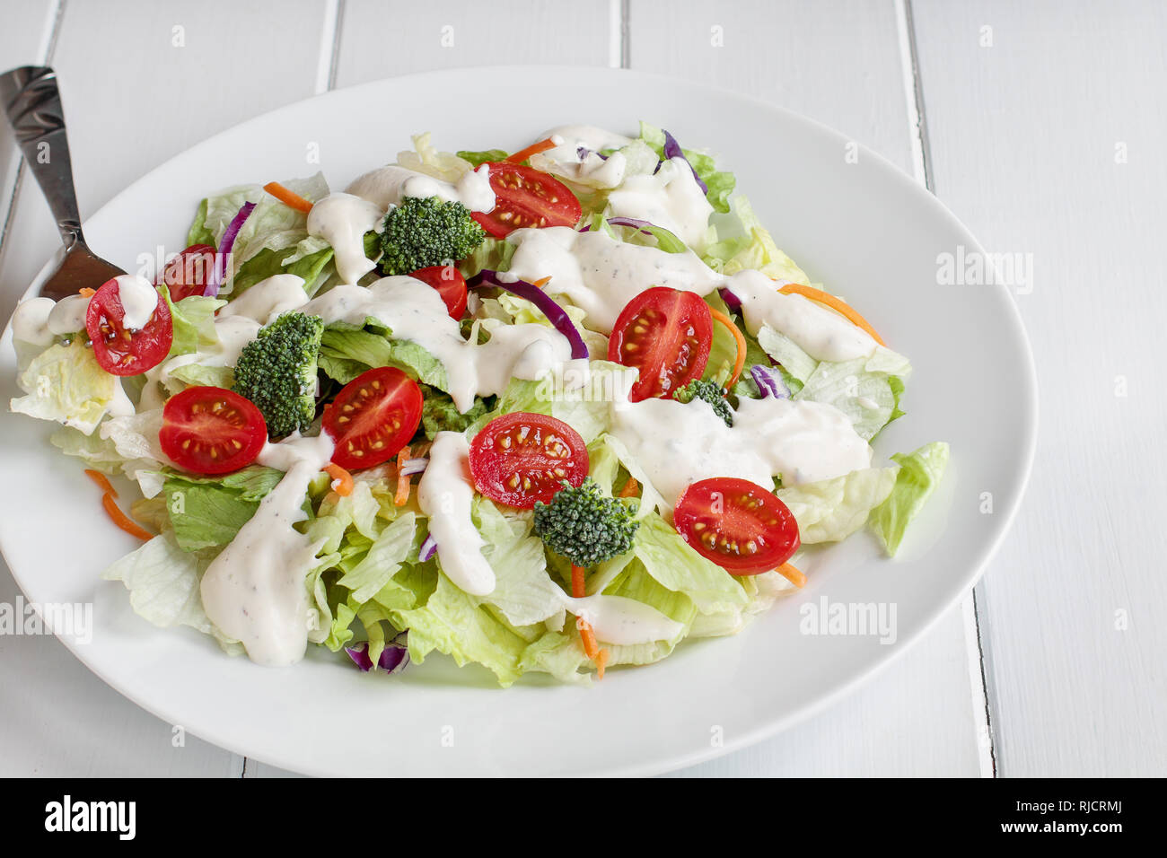 https://c8.alamy.com/comp/RJCRMJ/plate-of-homemade-fresh-salad-with-buttermilk-ranch-dressing-tomatoes-broccoli-cabbage-and-carrots-served-over-a-white-wooden-table-house-salad-RJCRMJ.jpg