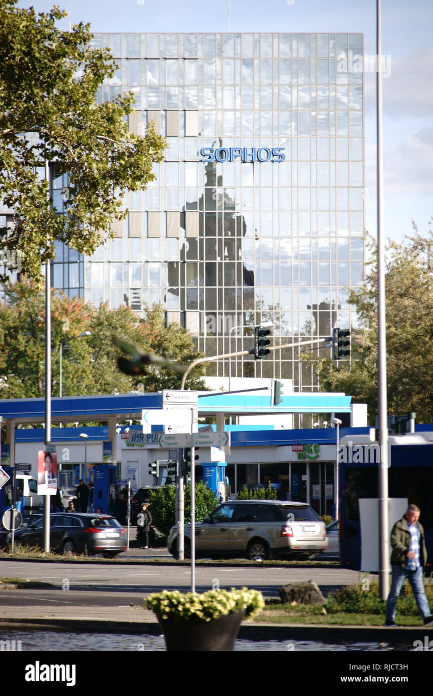 Wiesbaden, Germany - September 25, 2018: Traffic at a gas station and pedestrians in front of the modern skyscraper and office building of Sophos on S Stock Photo