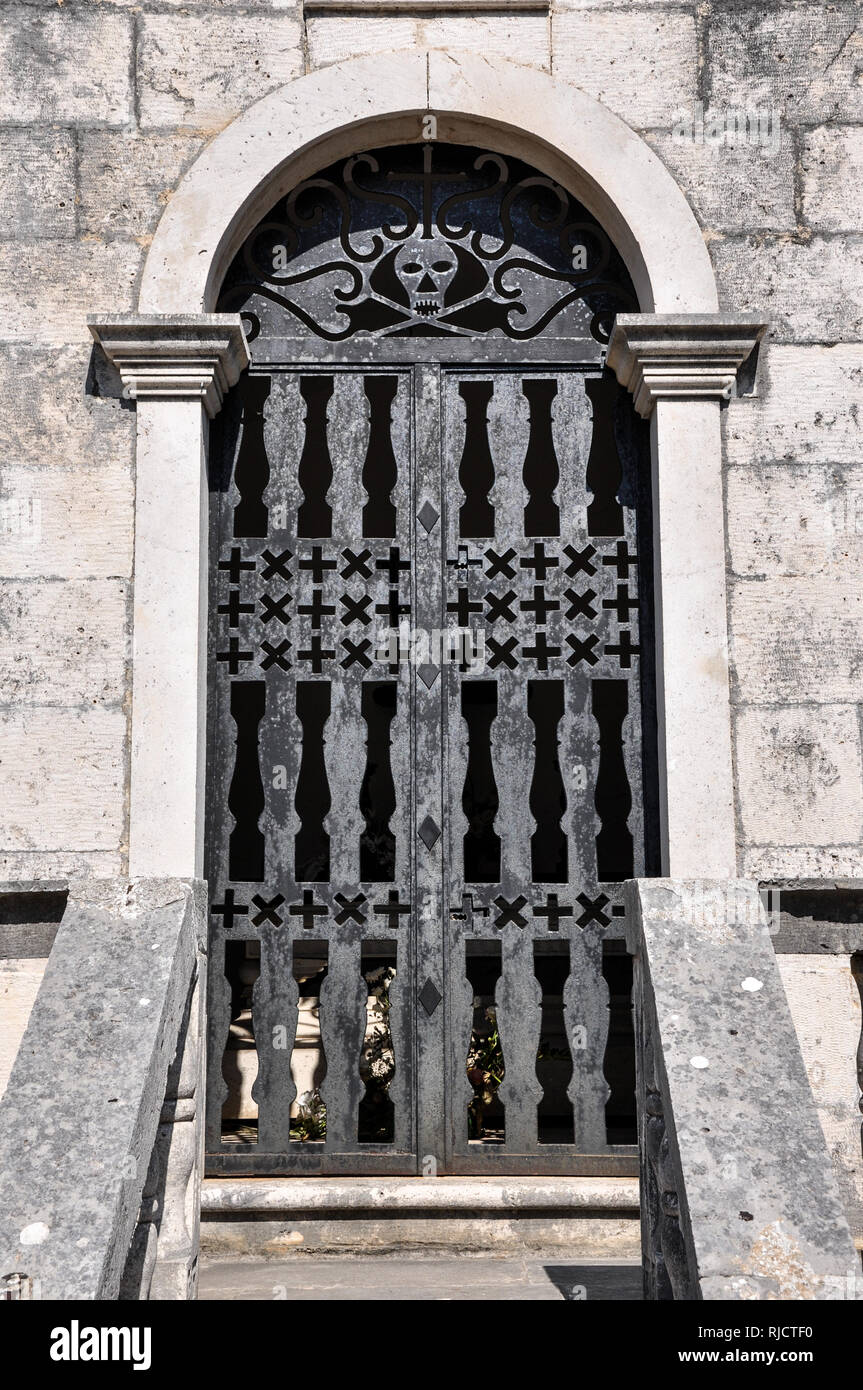 An ornate metal gate featuring a stylised skull at the entrance to a tomb in the cemetery of Our Lady of the Angels Monastery, Podgorje, Croatia Stock Photo