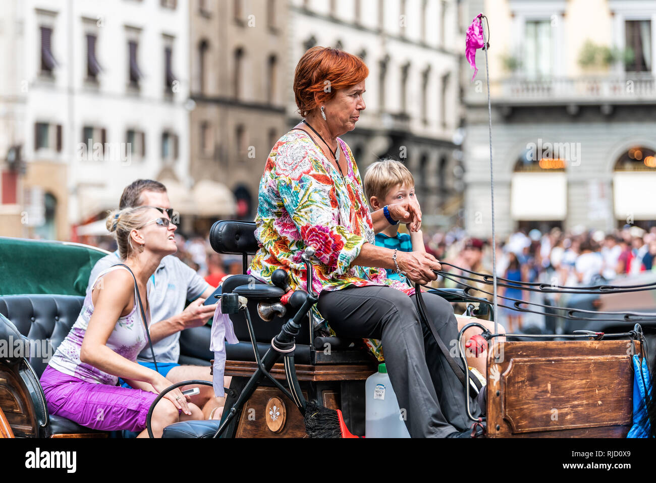 Firenze, Italy - August 30, 2018: Tourists people with tour guide riding horse carriage outside on summer day in Florence, Tuscany Stock Photo