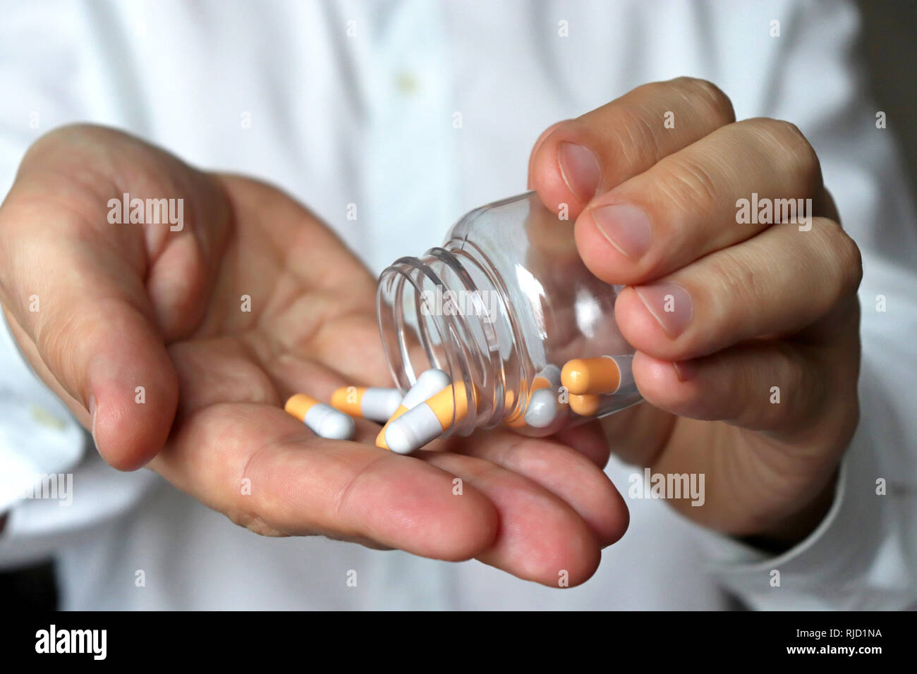Doctor with pills, man in white lab coat giving medication in capsules. Concept of medical exam, hospital, dose of drugs, vitamins, pharmacy, flu trea Stock Photo
