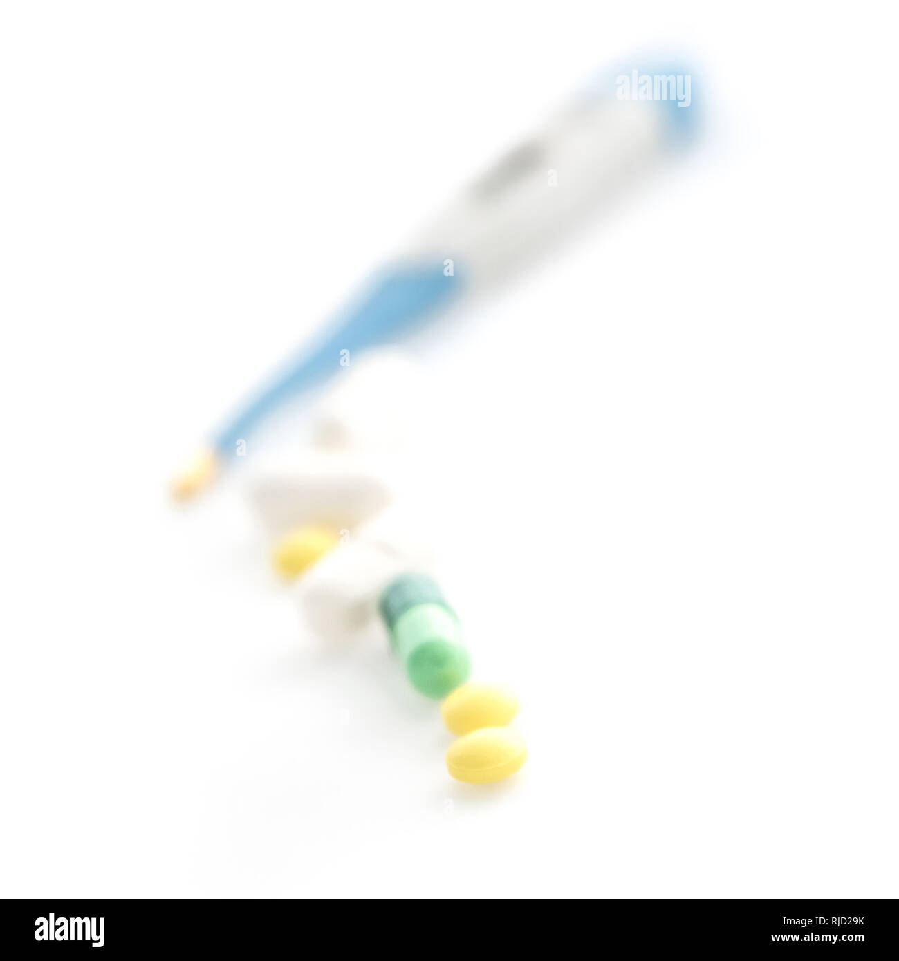 Isolated Digital Thermometer with pills on white background Stock Photo