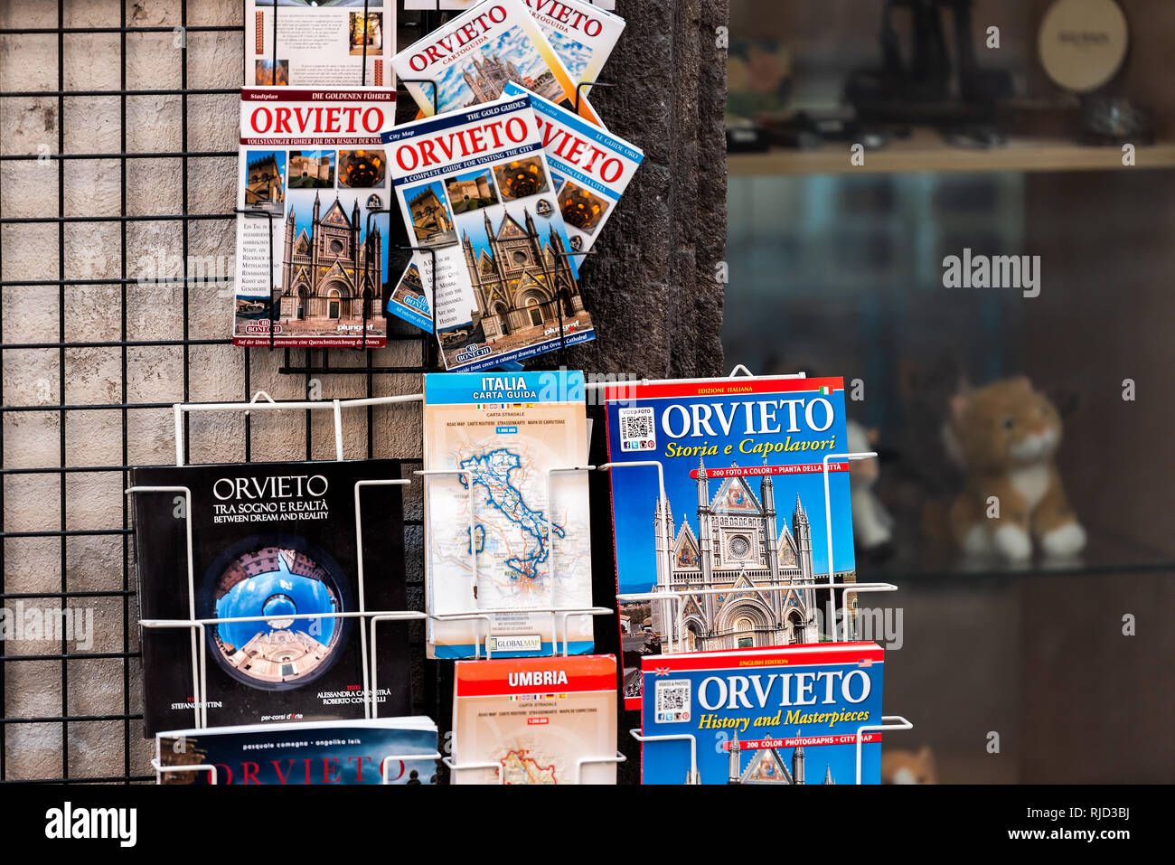 Orvieto, Italy - September 3, 2018: Closeup of shopping souvenirs and map tour travel guide in small Italian town city street vendor retail display Stock Photo