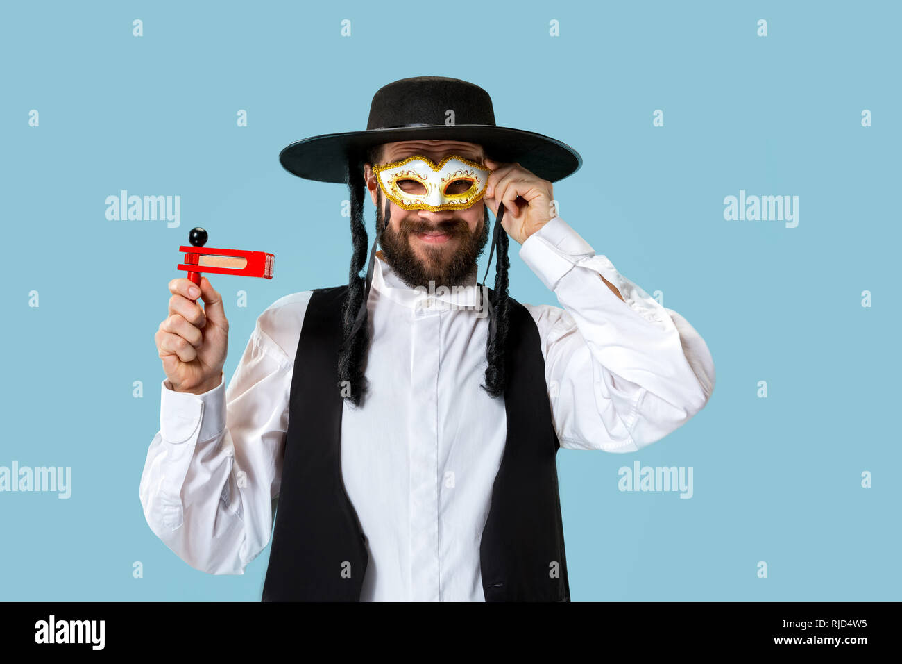 Portrait of a young orthodox Hasdim Jewish man with wooden Grager ...