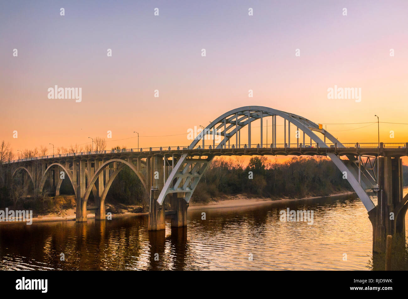 The sun sets behind the Edmund Pettus Bridge, Feb. 14, 2015, in Selma, Alabama. The bridge played an important role in the Civil Rights Movement. Stock Photo