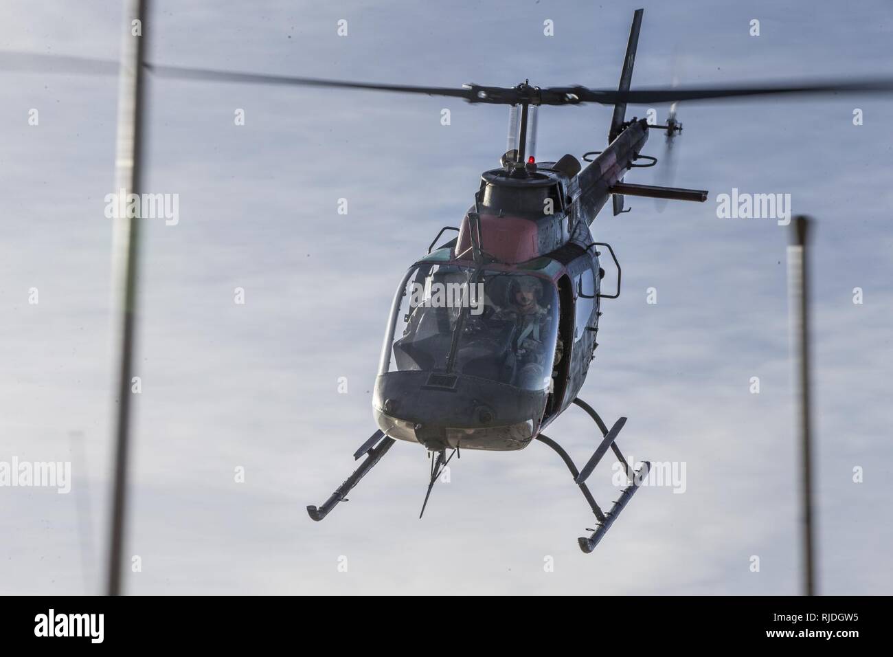 A U.S. Army Bell OH-58 Kiowa flies through the air during a field training exercise at the National Training Center (NTC) in Fort Irwin, Calif., Jan. 15, 2018. NTC 18-03 is a simulated combat training exercise in which Marines with 2nd LAAD conducted Ground Based Air Defense in defense of Soldiers with 1st Squadron, 11th Armored Cavalry Regiment. Stock Photo