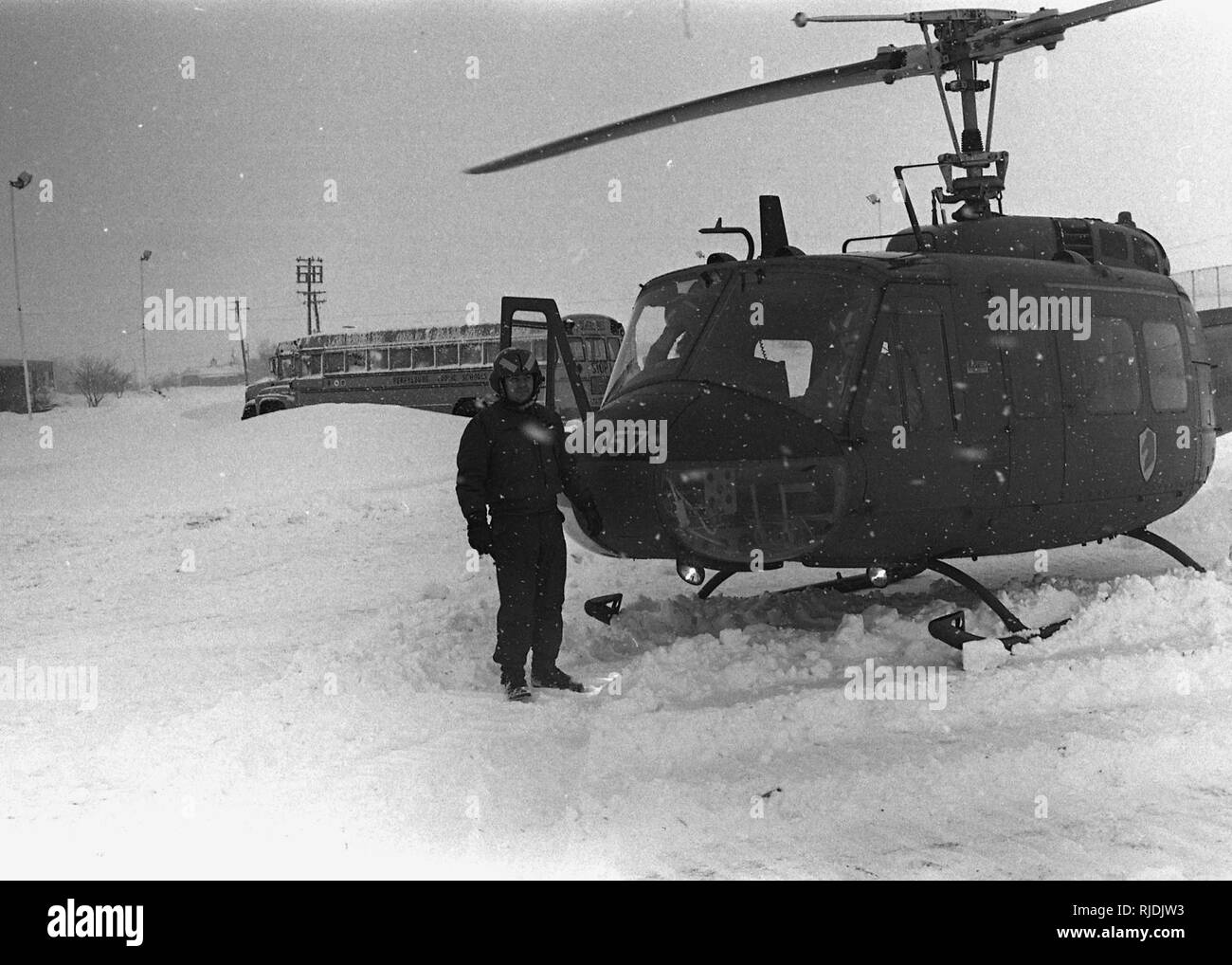 Sgt. James Monroe of Troop N, 107th Armored Cavalry stands outside of a UH-1 Iroquois “Huey” helicopter after it landed at Perrysburg High School, in Perrysburg, Ohio, during state active duty operations in support of the “Blizzard of ’78.” Ohio National Guard helicopter crews worked around the clock on medevac, rescue and resupply missions, averaging more than 200 flights a day during the peak period. (Ohio Army National Guard Historical Collections) Stock Photo
