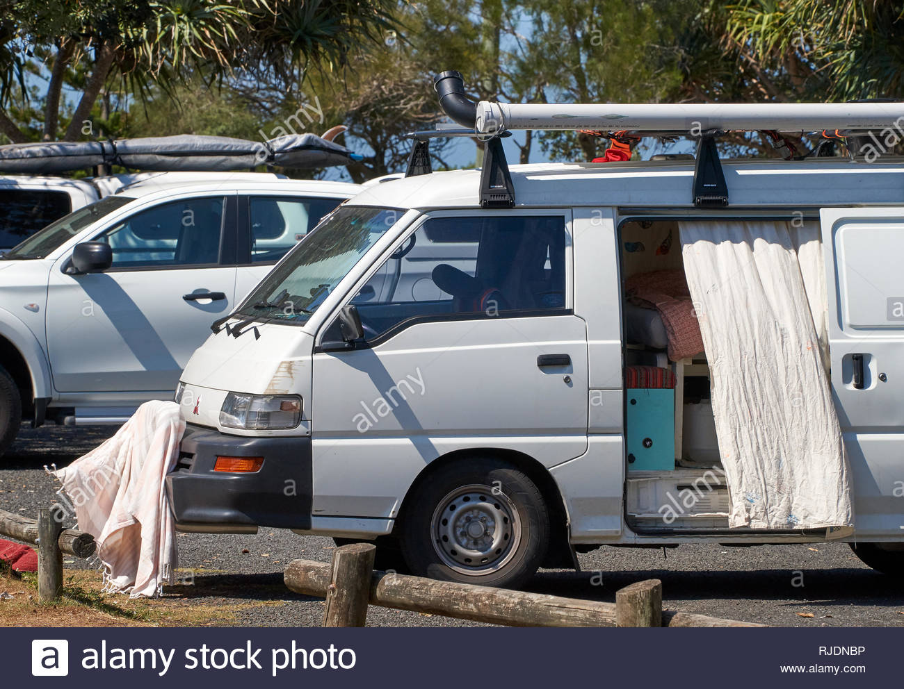 A Small Camper Van With It S Side Door Open Parked Beside Other