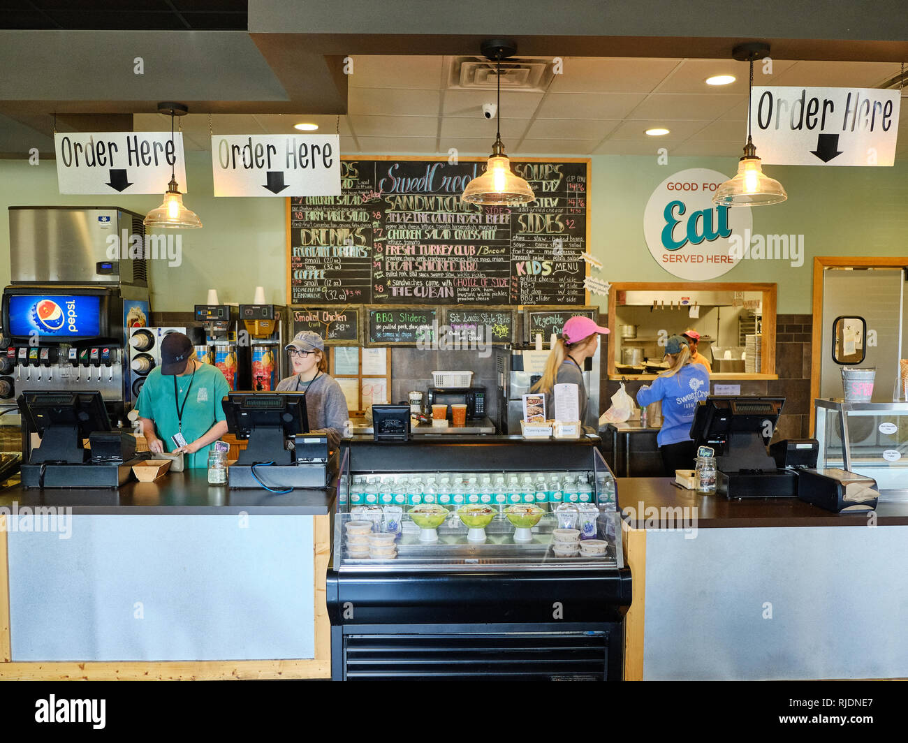 Deli cafe or restaurant front order counter with female employees working behind the counter at Sweet Creek Farm Market in Pike Road Alabama, USA. Stock Photo
