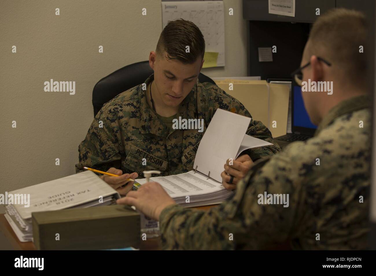 U.S. Marine Corps Cpl. Dylan Peterson, a refrigeration and air conditioning technician assigned to Marine Corps Air Control Squadron (MACS) 1, prepares taxes for a client at the Volunteer Income Tax Assistance (VITA) Tax Center at Marine Corps Air Station (MCAS) Yuma, Ariz., Jan. 22, 2018. The VITA Tax Center offers free tax preparation to all service members, Department of Defense employees, and family members at MCAS Yuma. Stock Photo